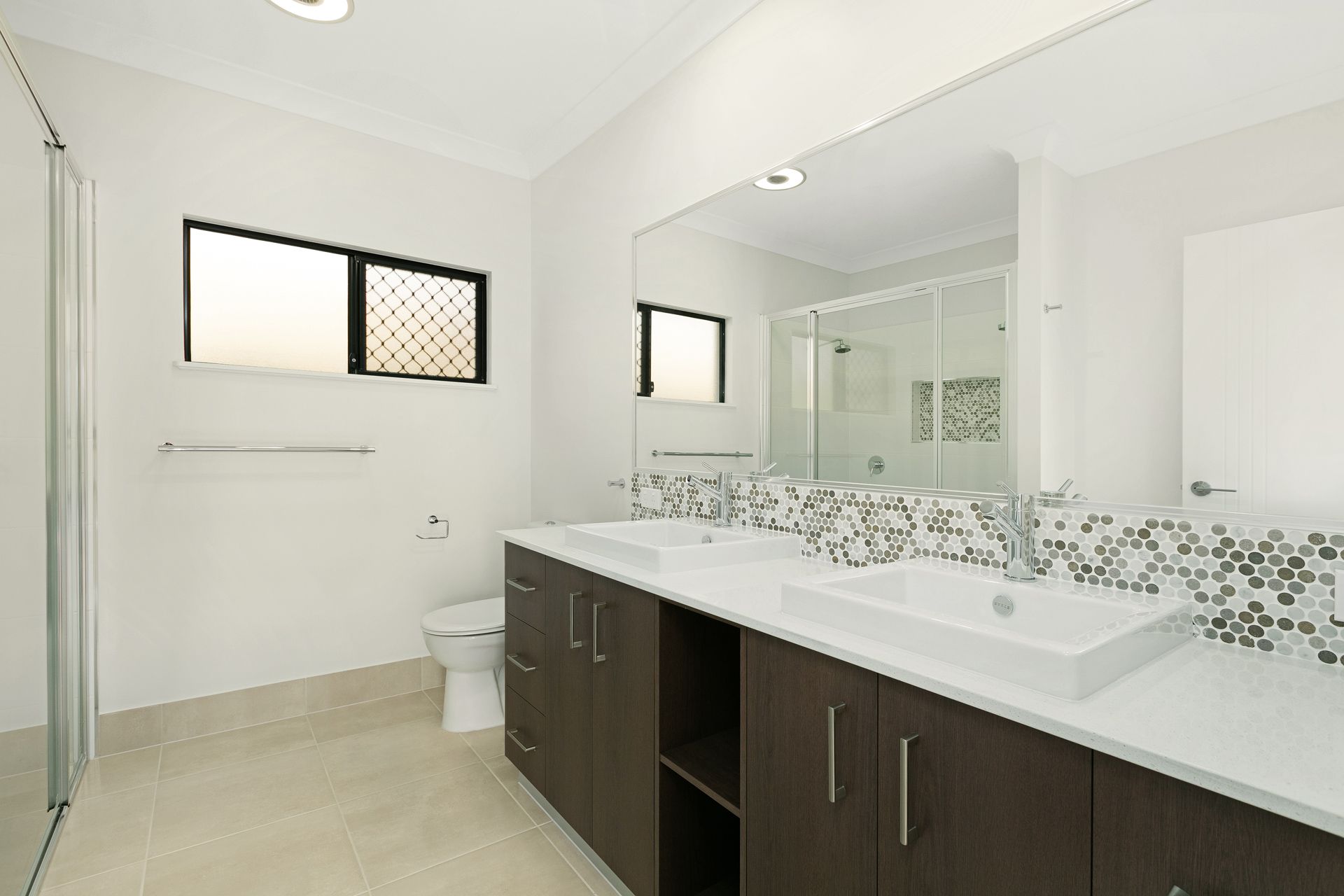 A Modern Bathroom Featuring a White Dual-sink Vanity — Ashlee Jones Homes in Gordonvale, QLD