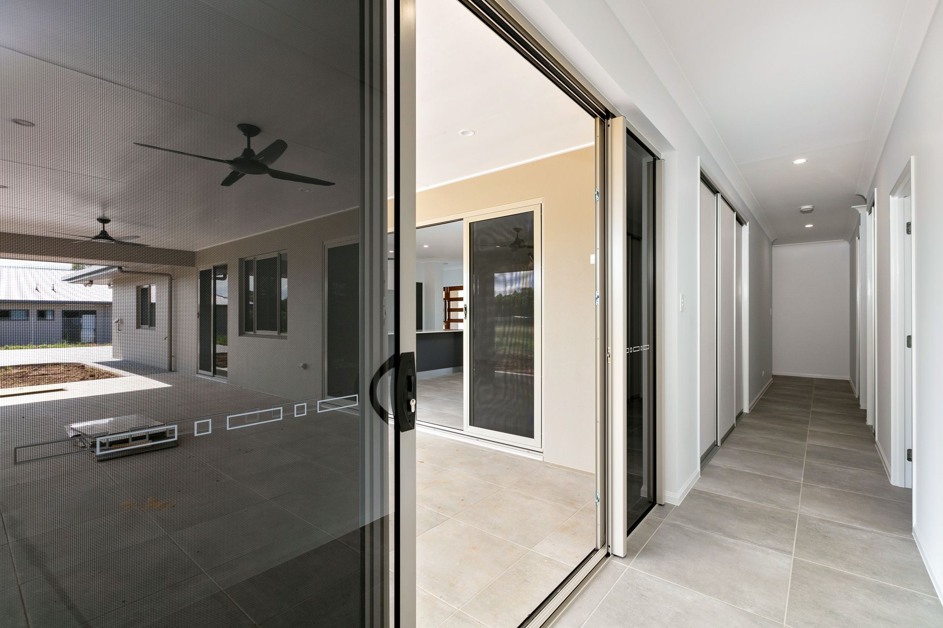 A Bright Hallway With Light-colored Tile Floors — Ashlee Jones Homes in Gordonvale, QLD