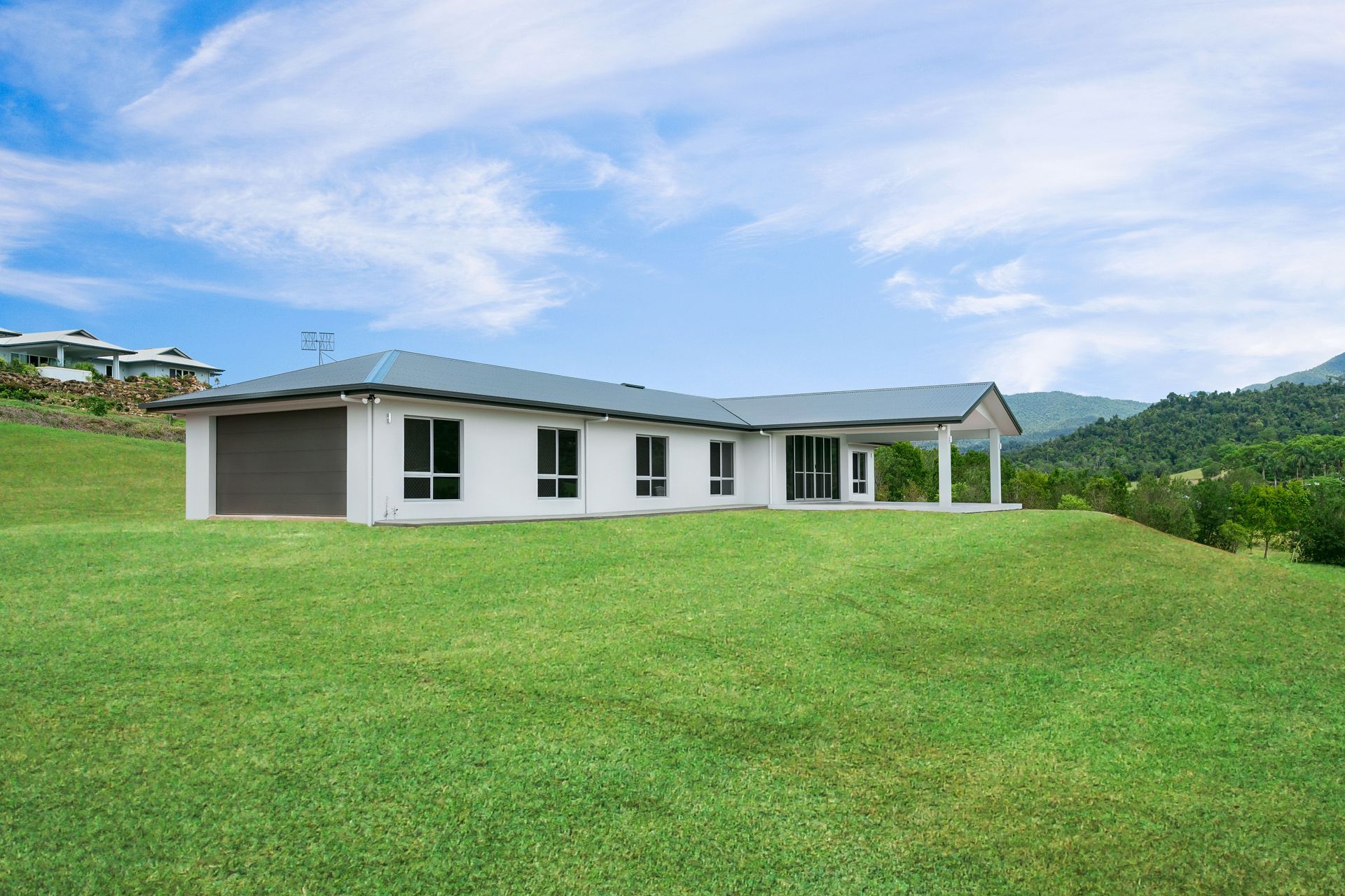 A White, Single-story House With a Grey Roof Sits — Ashlee Jones Homes in Gordonvale, QLD