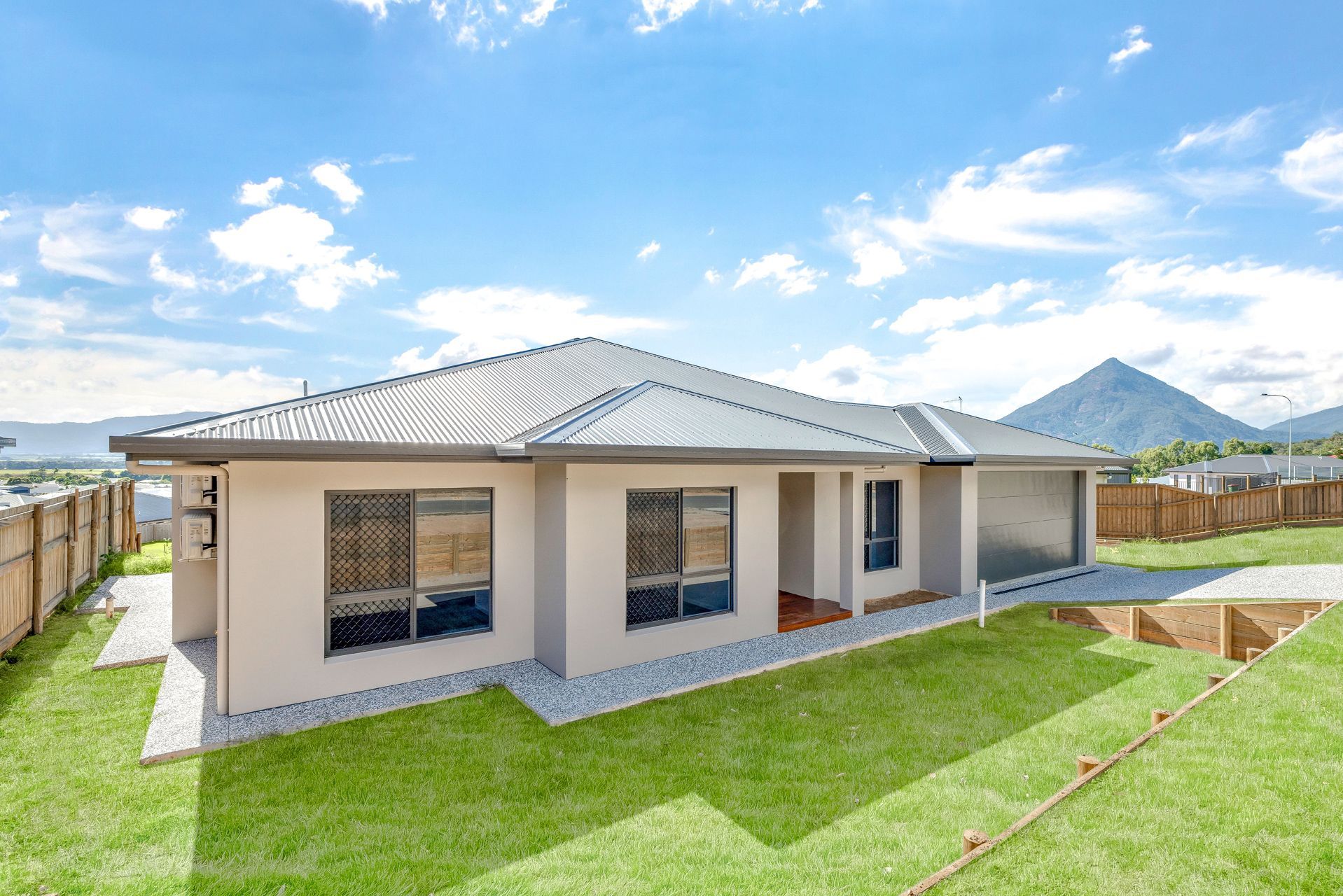 A Single-story, Light-colored Suburban House With a Tiled Roof and Garage — Ashlee Jones Homes in Gordonvale, QLD