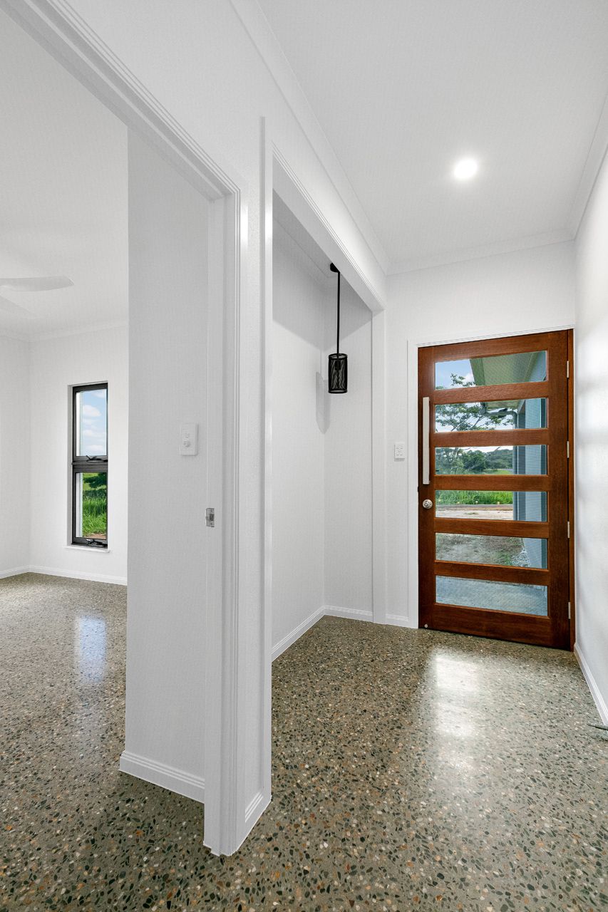 A Brightly Lit Entryway With Polished Concrete Floors — Ashlee Jones Homes in Gordonvale, QLD