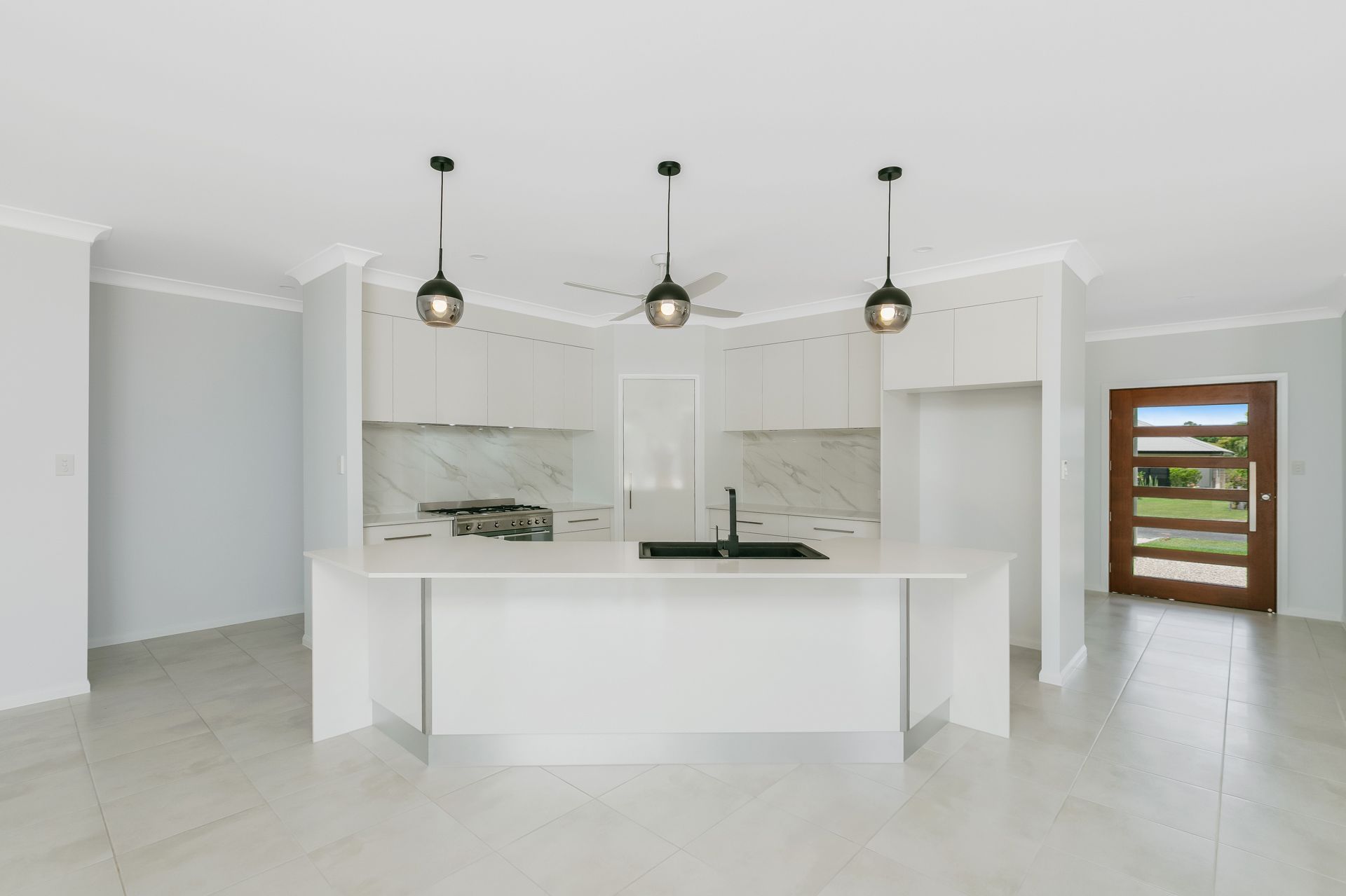 A Modern, White Kitchen Featuring a Central Island — Ashlee Jones Homes in Gordonvale, QLD