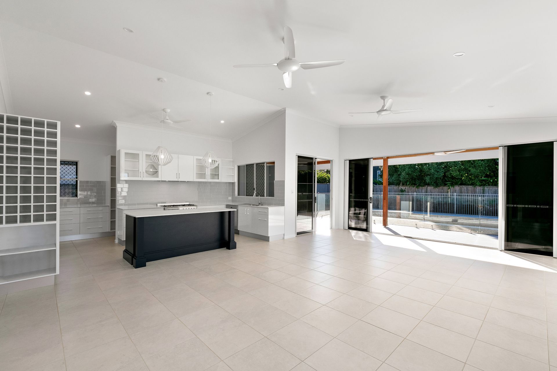 A Bright, Open-plan Kitchen and Living Area With White Walls — Ashlee Jones Homes in Gordonvale, QLD