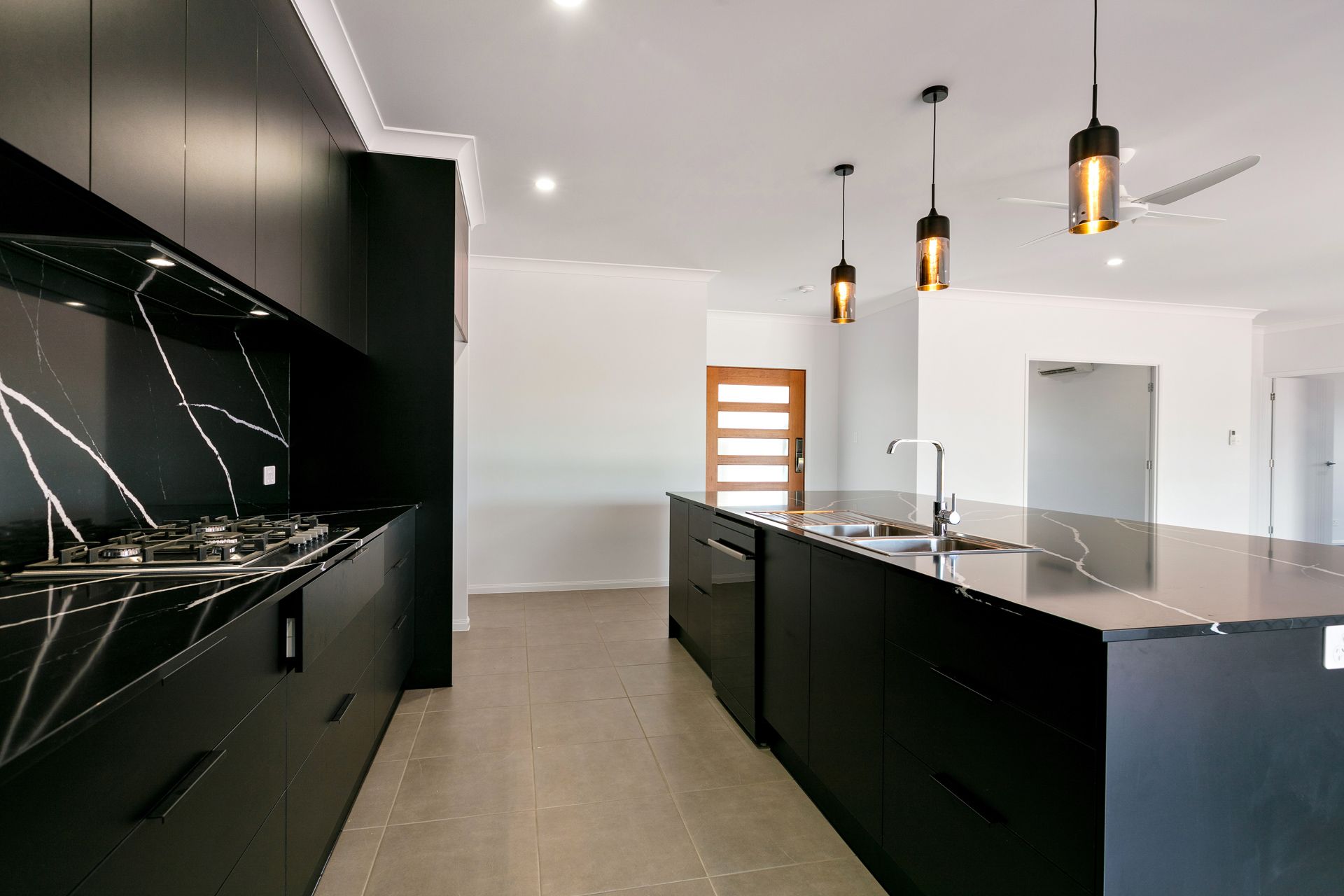 Modern Kitchen With Black Cabinetry, a Matching Island With a Sink — Ashlee Jones Homes in Gordonvale, QLD