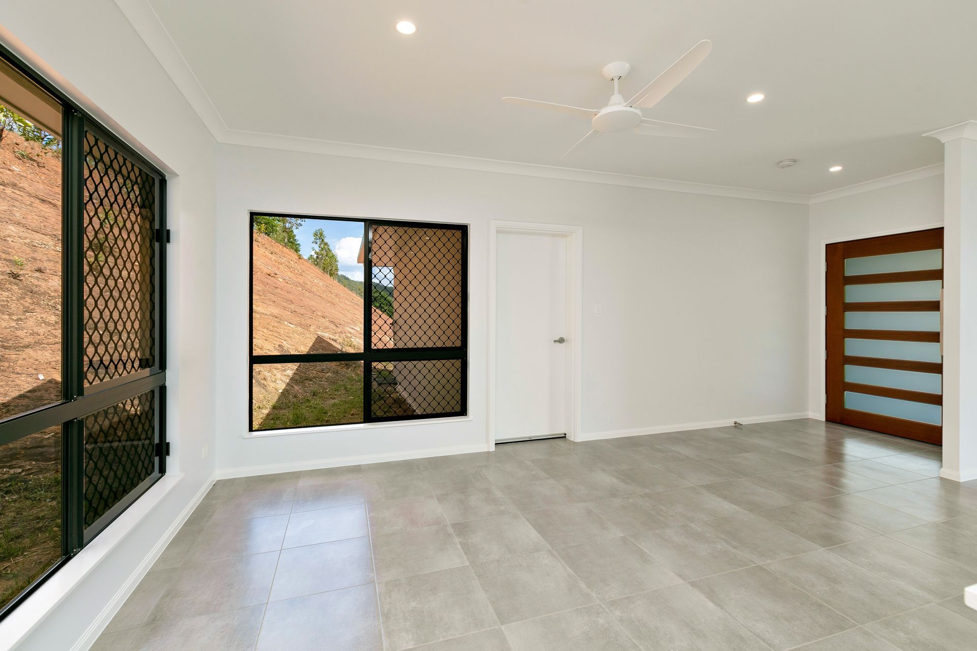 A Bright, Modern Room With Light Grey Tile Floors — Ashlee Jones Homes in Gordonvale, QLD