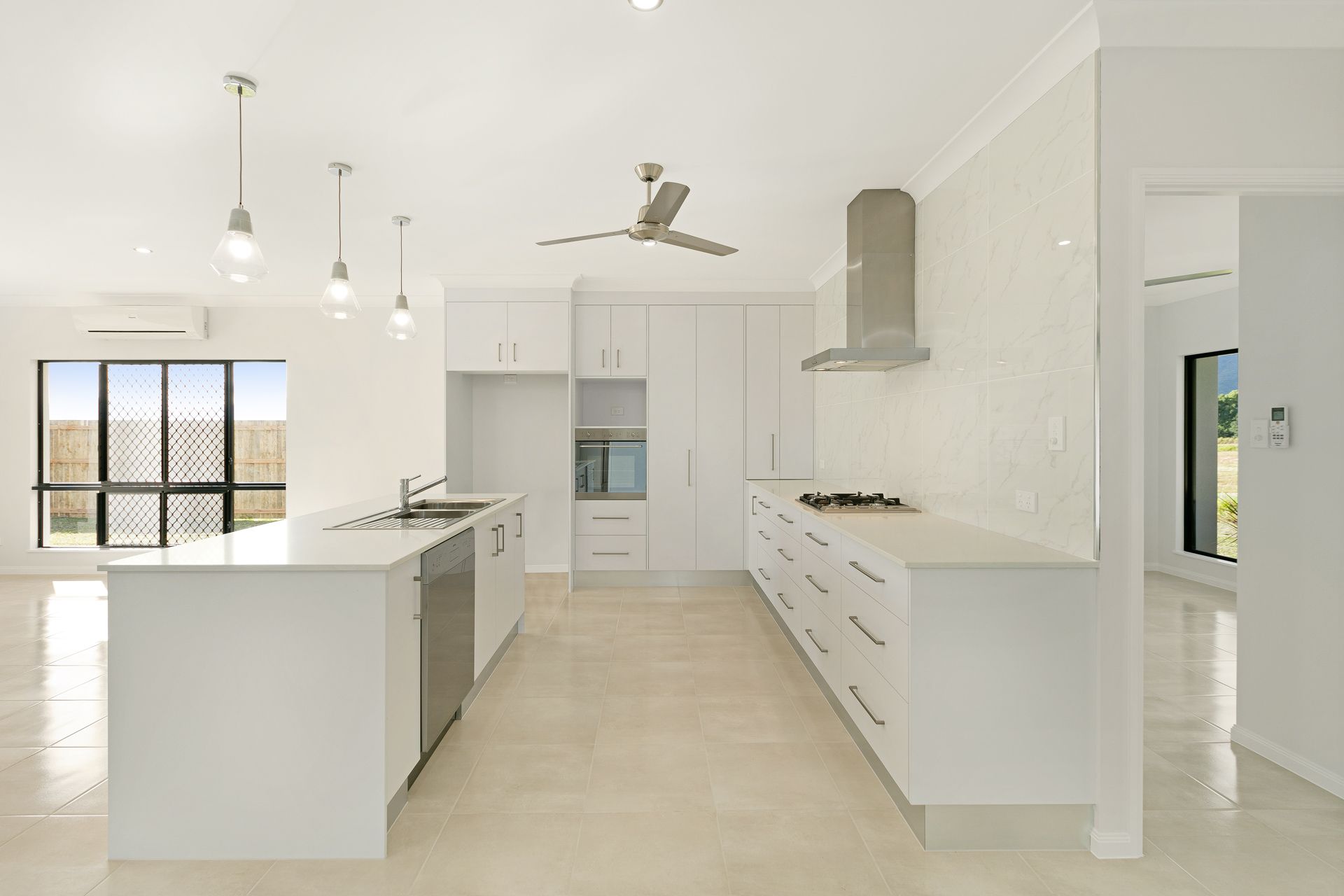 Modern Kitchen With White Cabinets, Light Stone Floors — Ashlee Jones Homes in Gordonvale, QLD