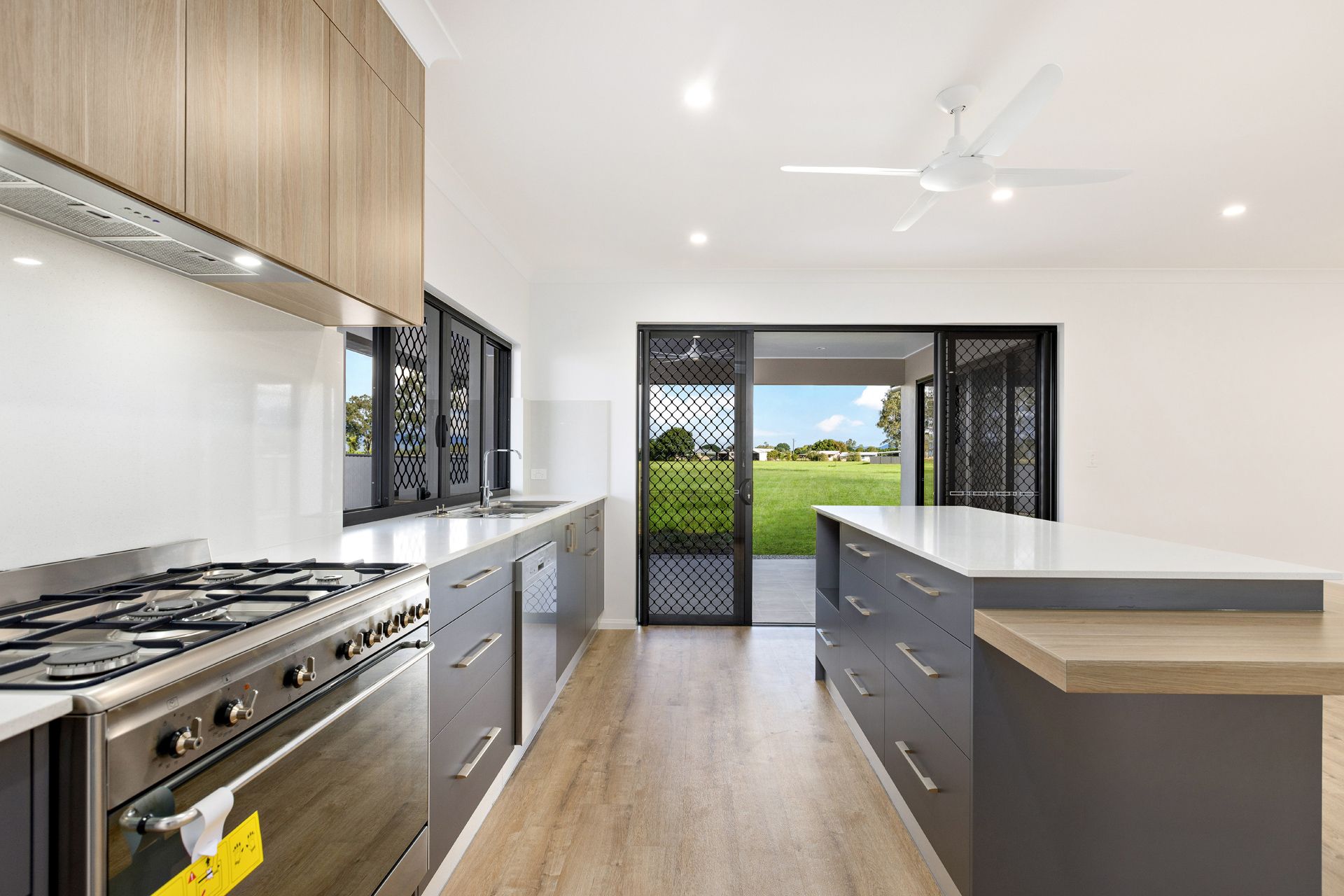 Modern Kitchen With Grey Cabinets, Light Wood Uppers — Ashlee Jones Homes in Gordonvale, QLD