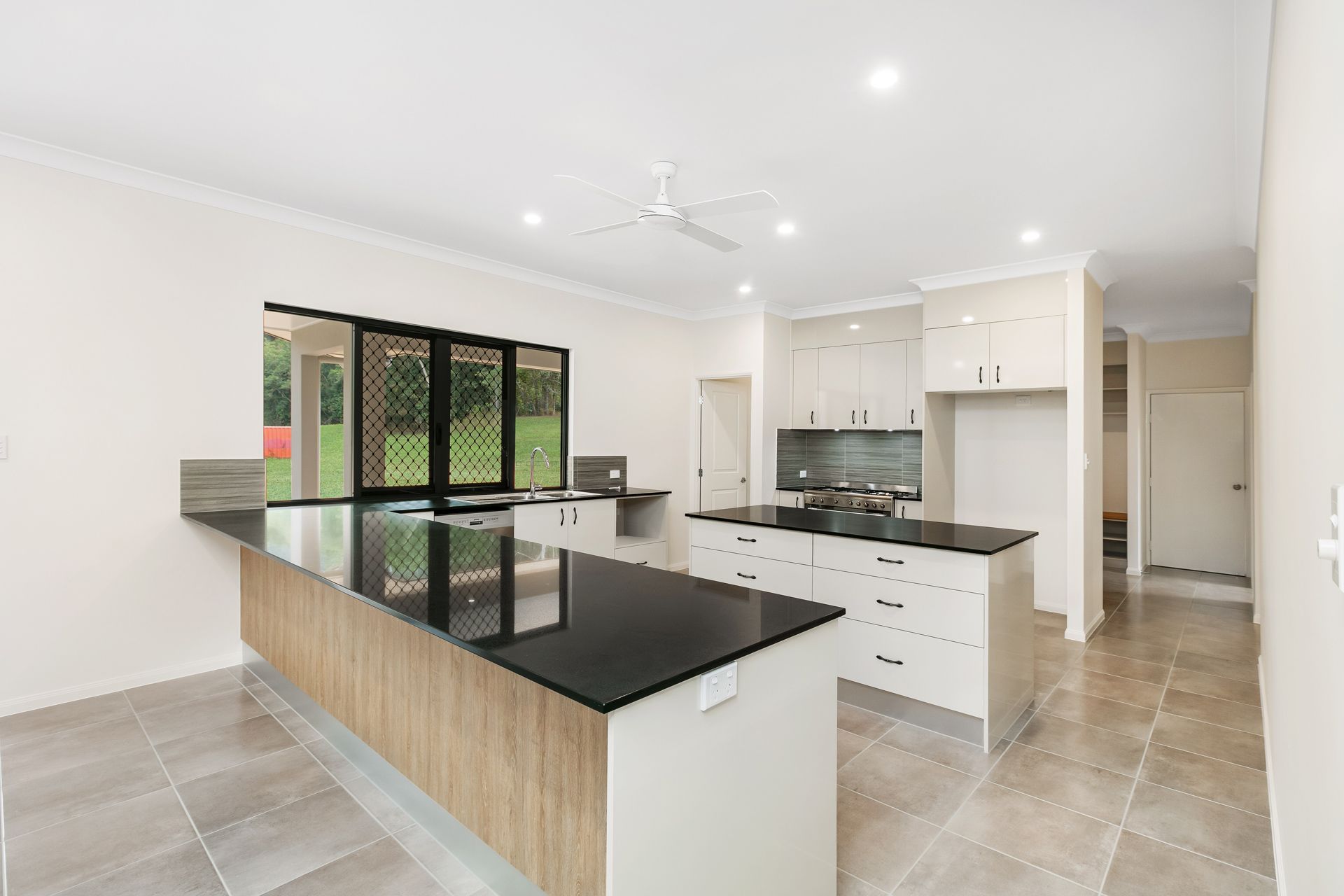 Modern Kitchen Featuring White Cabinetry — Ashlee Jones Homes in Gordonvale, QLD