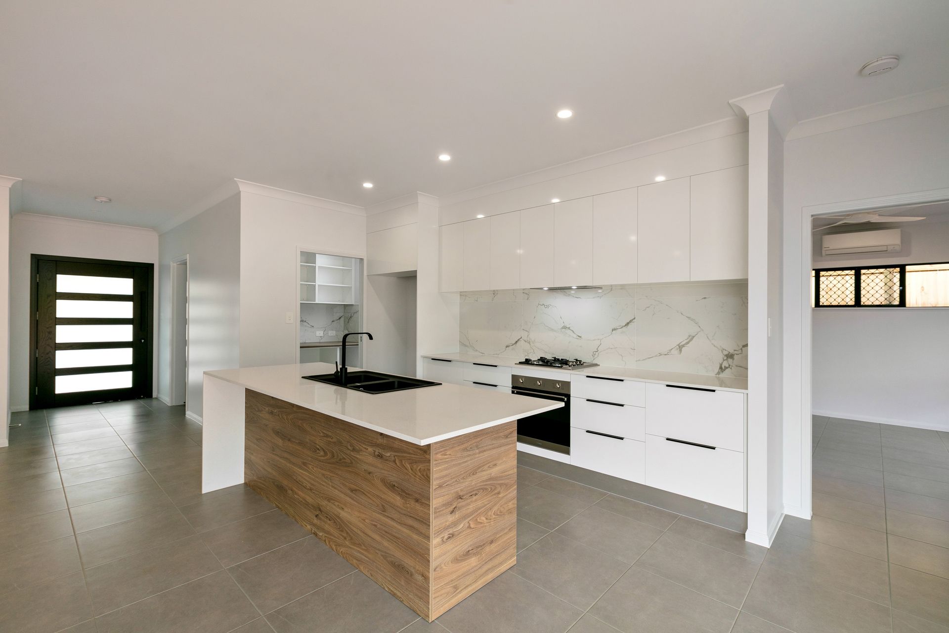 Modern Kitchen With a Wood-grain Island, White Cabinetry — Ashlee Jones Homes in Gordonvale, QLD