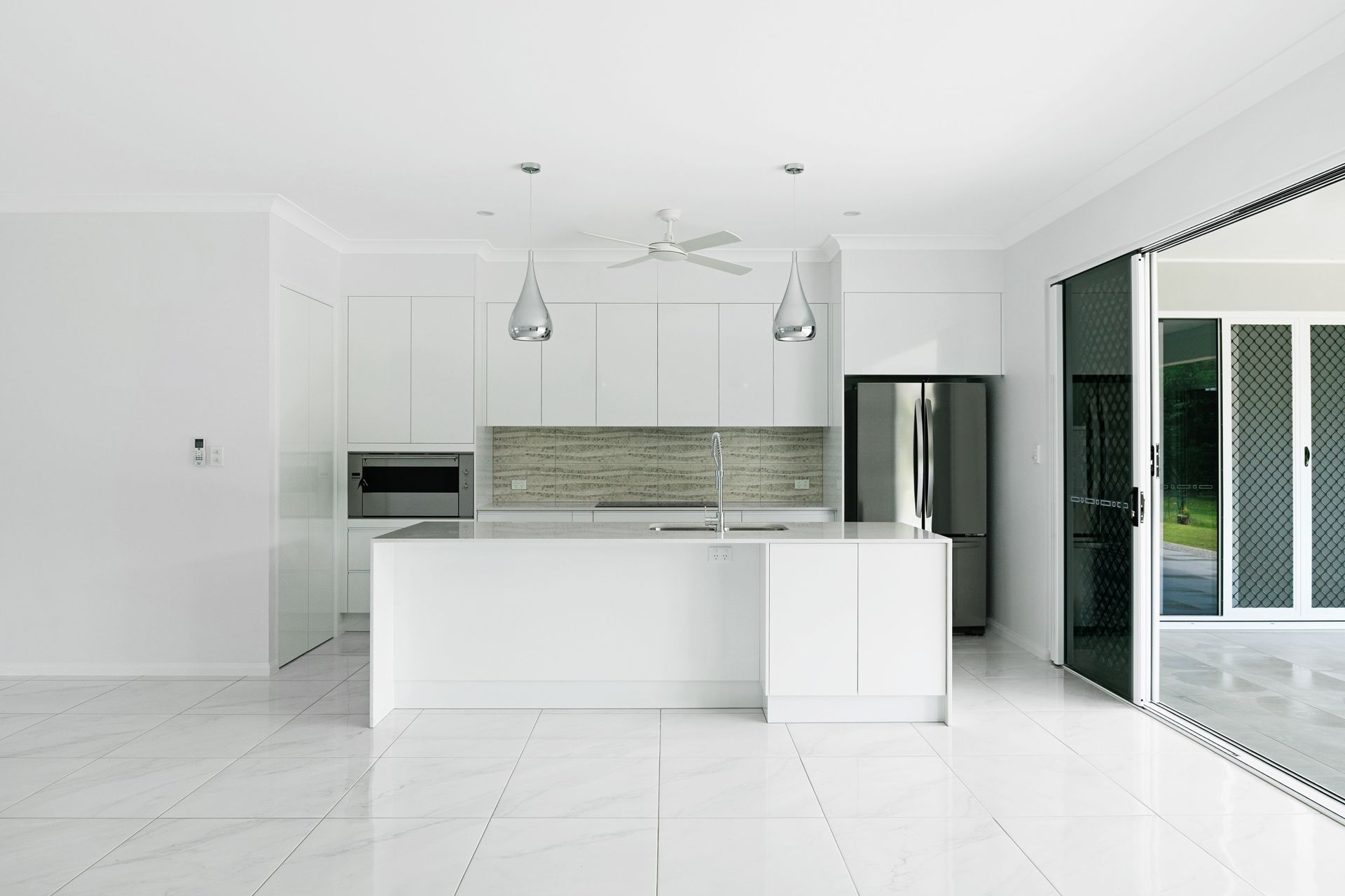 Modern All-white Kitchen With a Large Island — Ashlee Jones Homes in Gordonvale, QLD