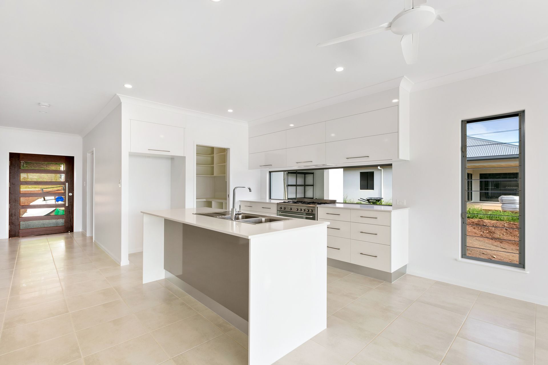 Modern, White Kitchen With a Central Island, Stainless Steel Stovetop — Ashlee Jones Homes in Gordonvale, QLD
