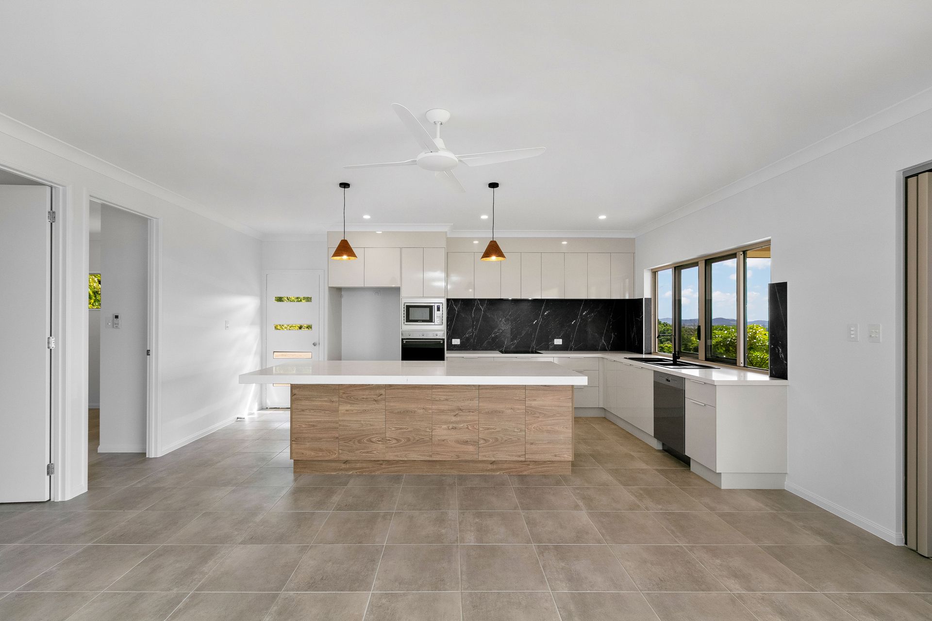 A Modern Kitchen With White Cabinetry — Ashlee Jones Homes in Gordonvale, QLD