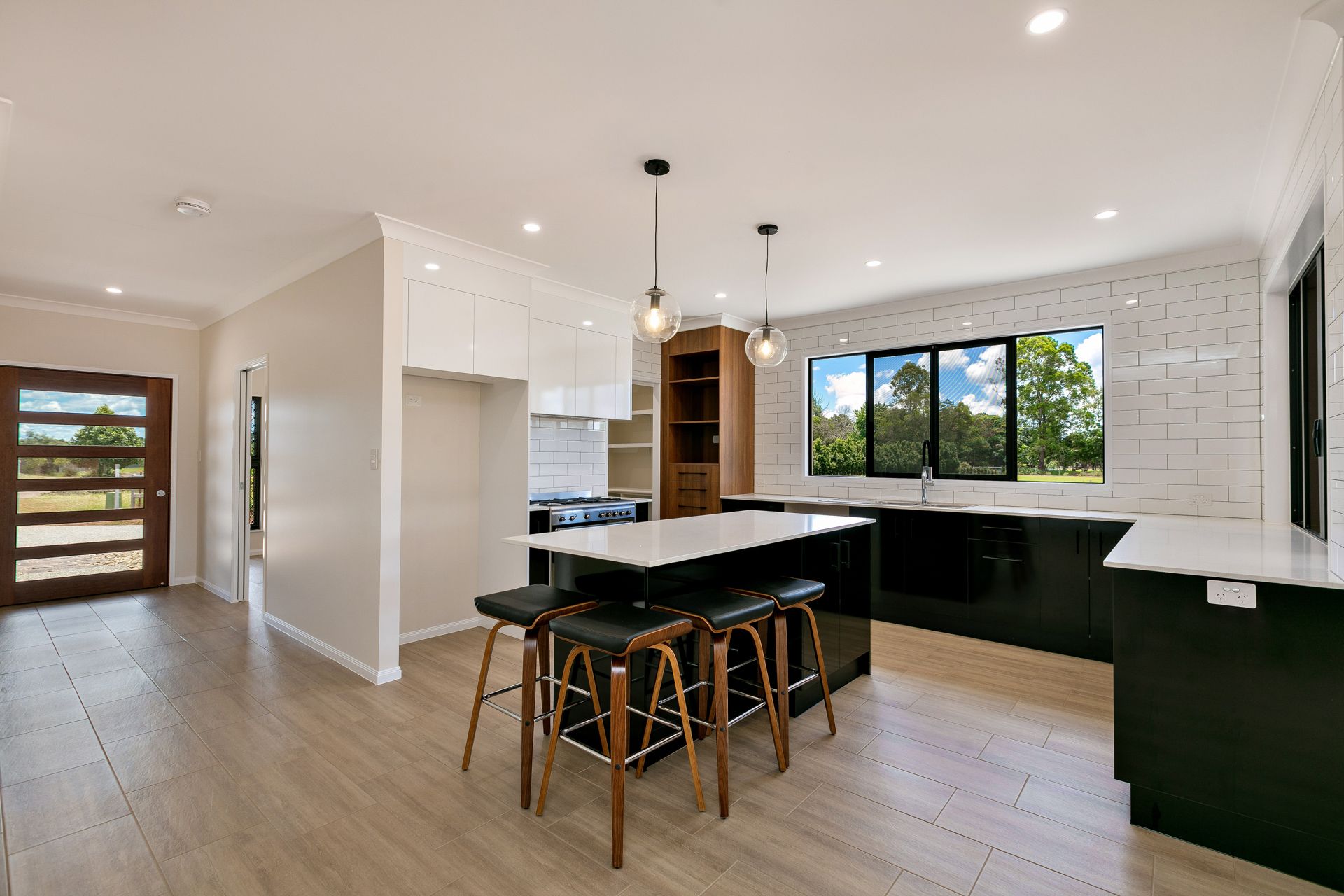 Modern Kitchen With a Black Island, White Counters — Ashlee Jones Homes in Gordonvale, QLD