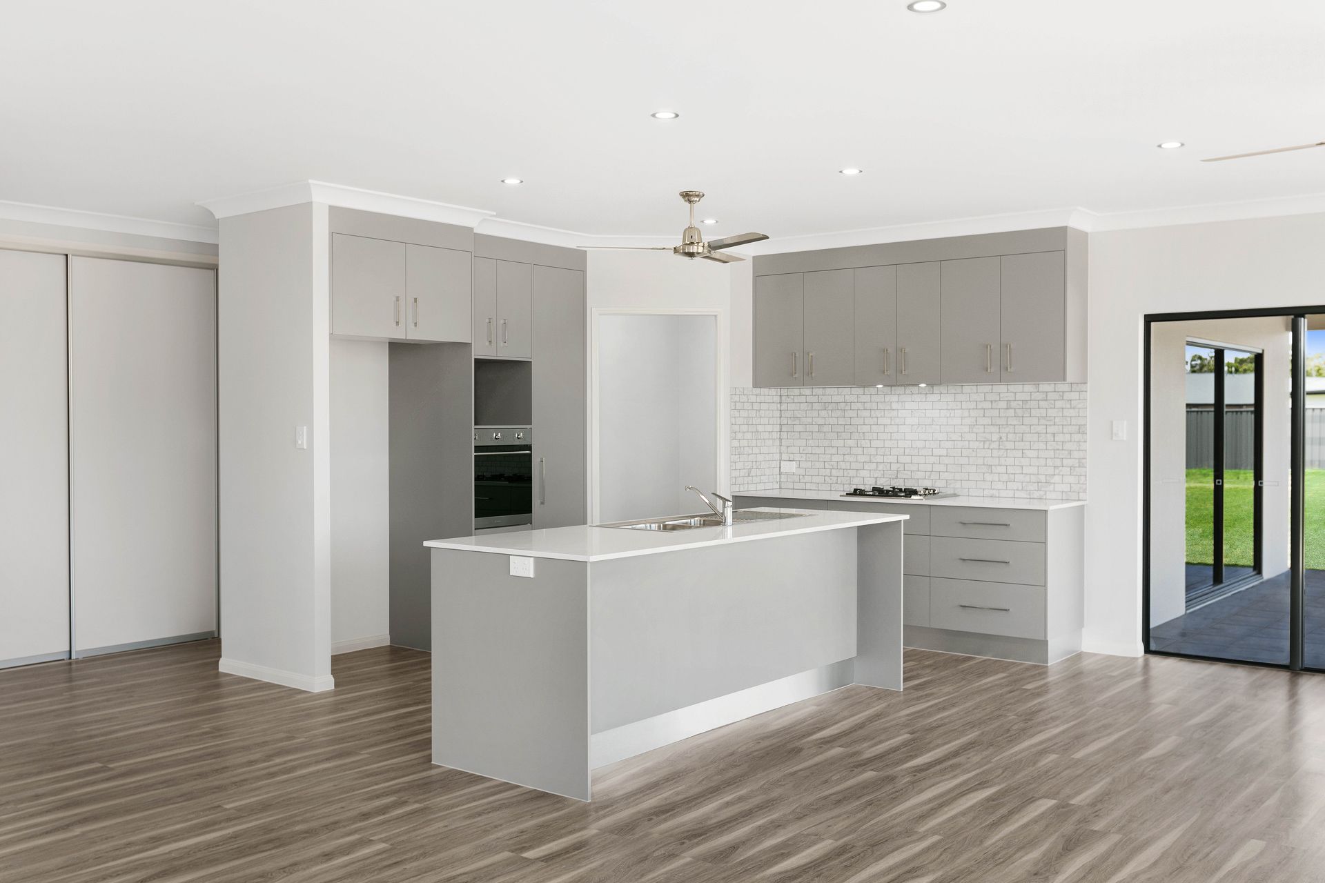 A Modern Kitchen Featuring a Gray Island, Light Cabinetry — Ashlee Jones Homes in Gordonvale, QLD