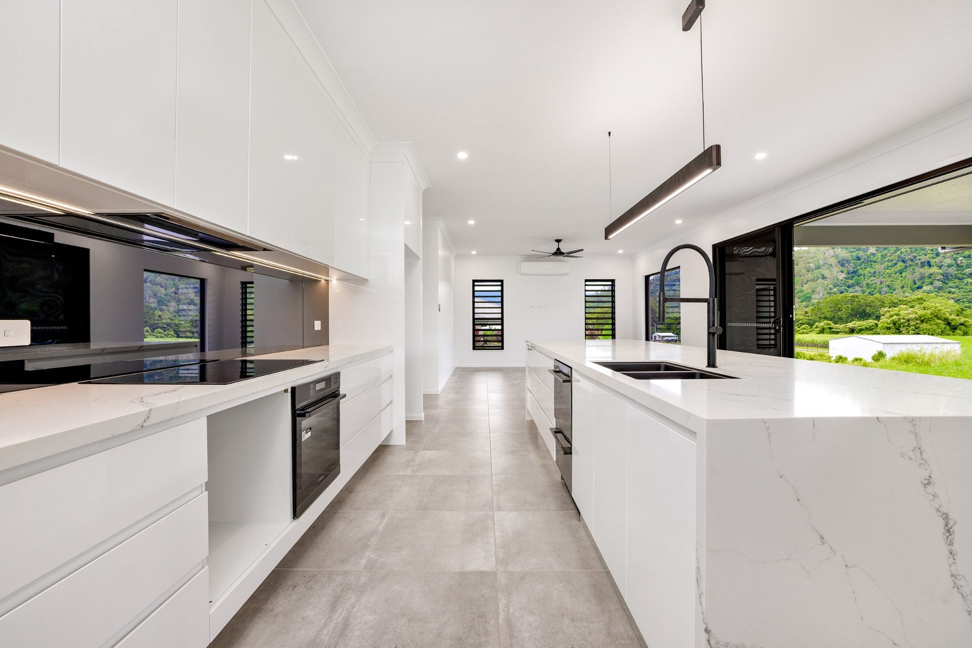 A Modern, Minimalist White Kitchen With a Large Marble Island — Ashlee Jones Homes in Gordonvale, QLD