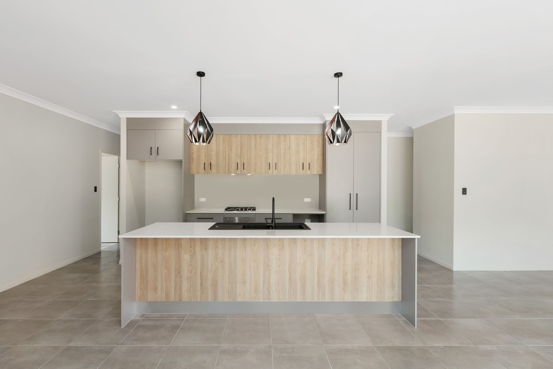 A Modern Kitchen With Light Wood Cabinets — Ashlee Jones Homes in Gordonvale, QLD