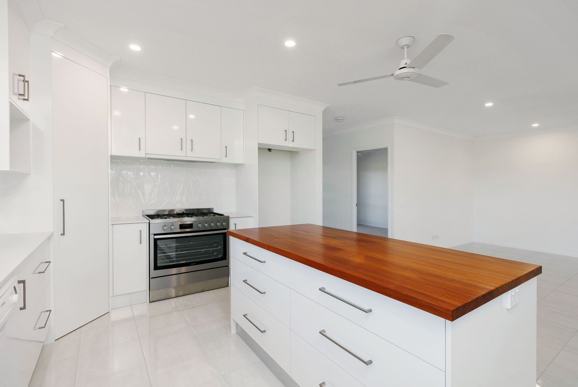 A Modern Kitchen Featuring White Cabinets — Ashlee Jones Homes in Gordonvale, QLD