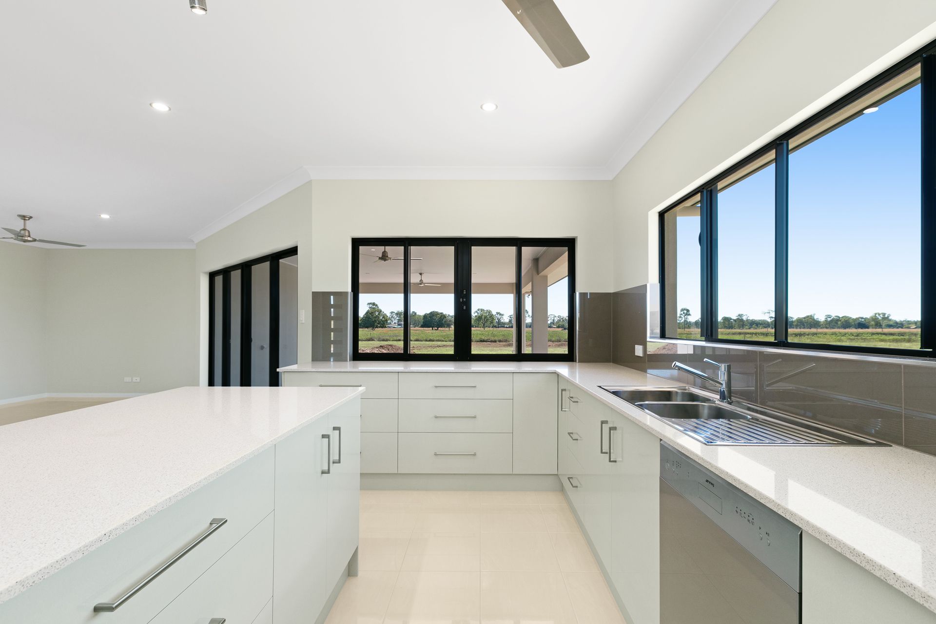 A Modern, White-toned Kitchen With a Central Island — Ashlee Jones Homes in Gordonvale, QLD