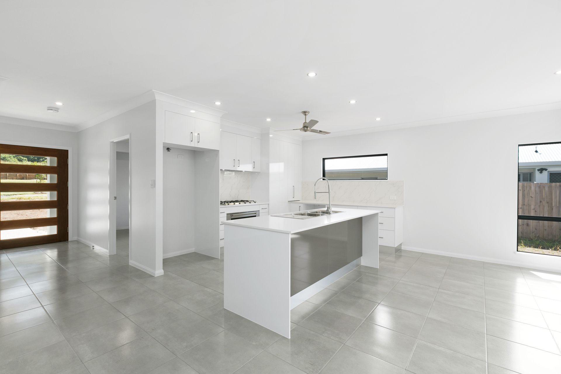 A Modern, Bright Kitchen Featuring White Cabinets — Ashlee Jones Homes in Gordonvale, QLD