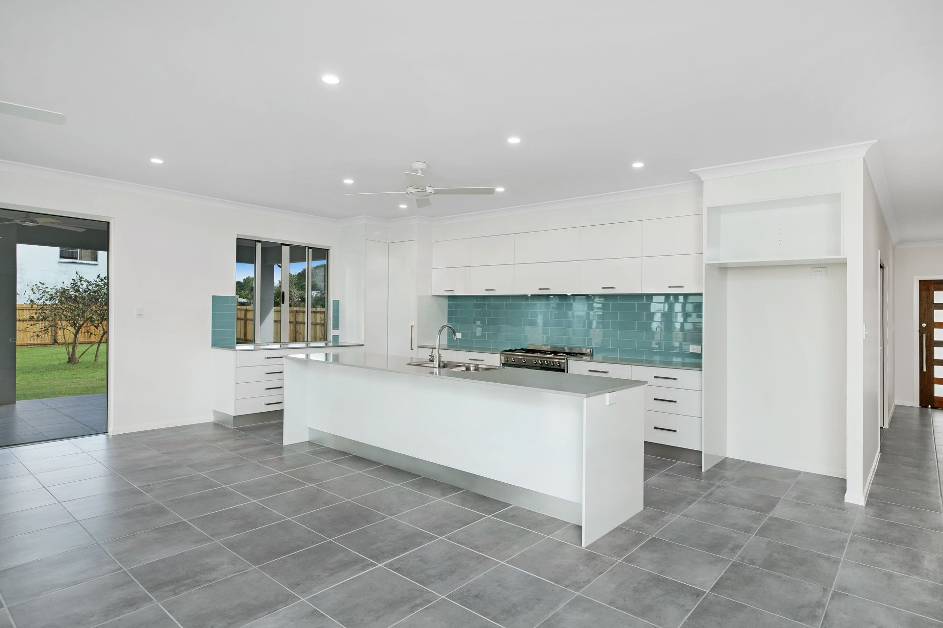 A Bright, Modern Kitchen Featuring a White Island — Ashlee Jones Homes in Gordonvale, QLD