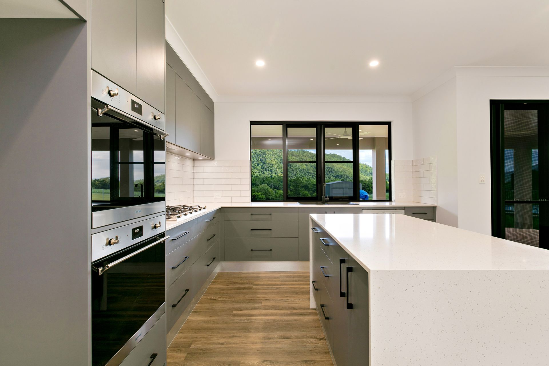 Modern Kitchen Featuring Grey Cabinetry, a White Quartz Island — Ashlee Jones Homes in Gordonvale, QLD