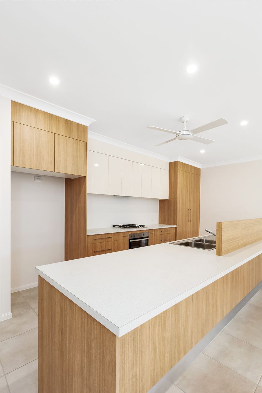 Modern Kitchen With a Large Island, Light Wood Cabinetry — Ashlee Jones Homes in Gordonvale, QLD