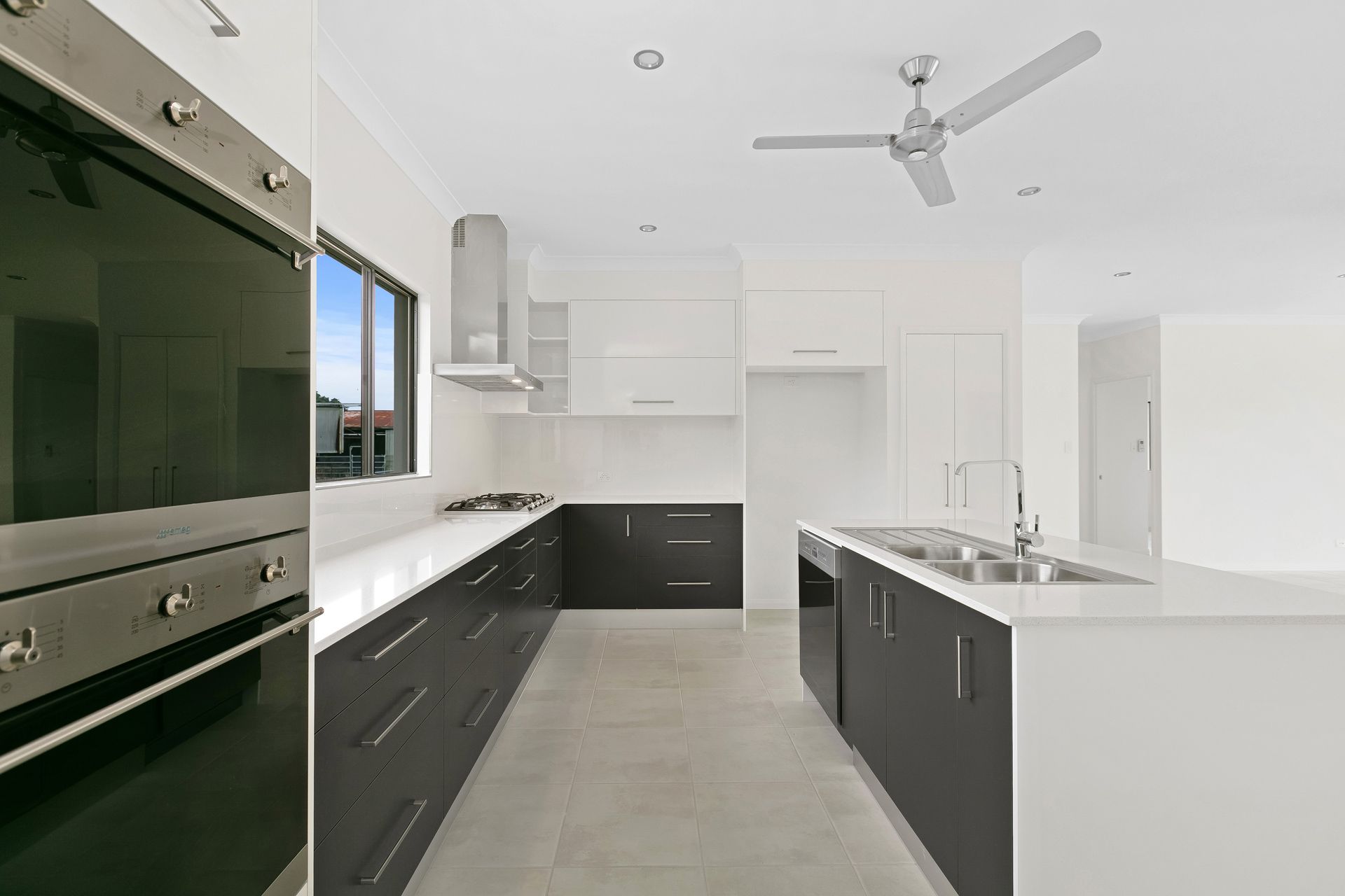 Modern Kitchen With White Counters, Dark Grey Cabinetry — Ashlee Jones Homes in Gordonvale, QLD