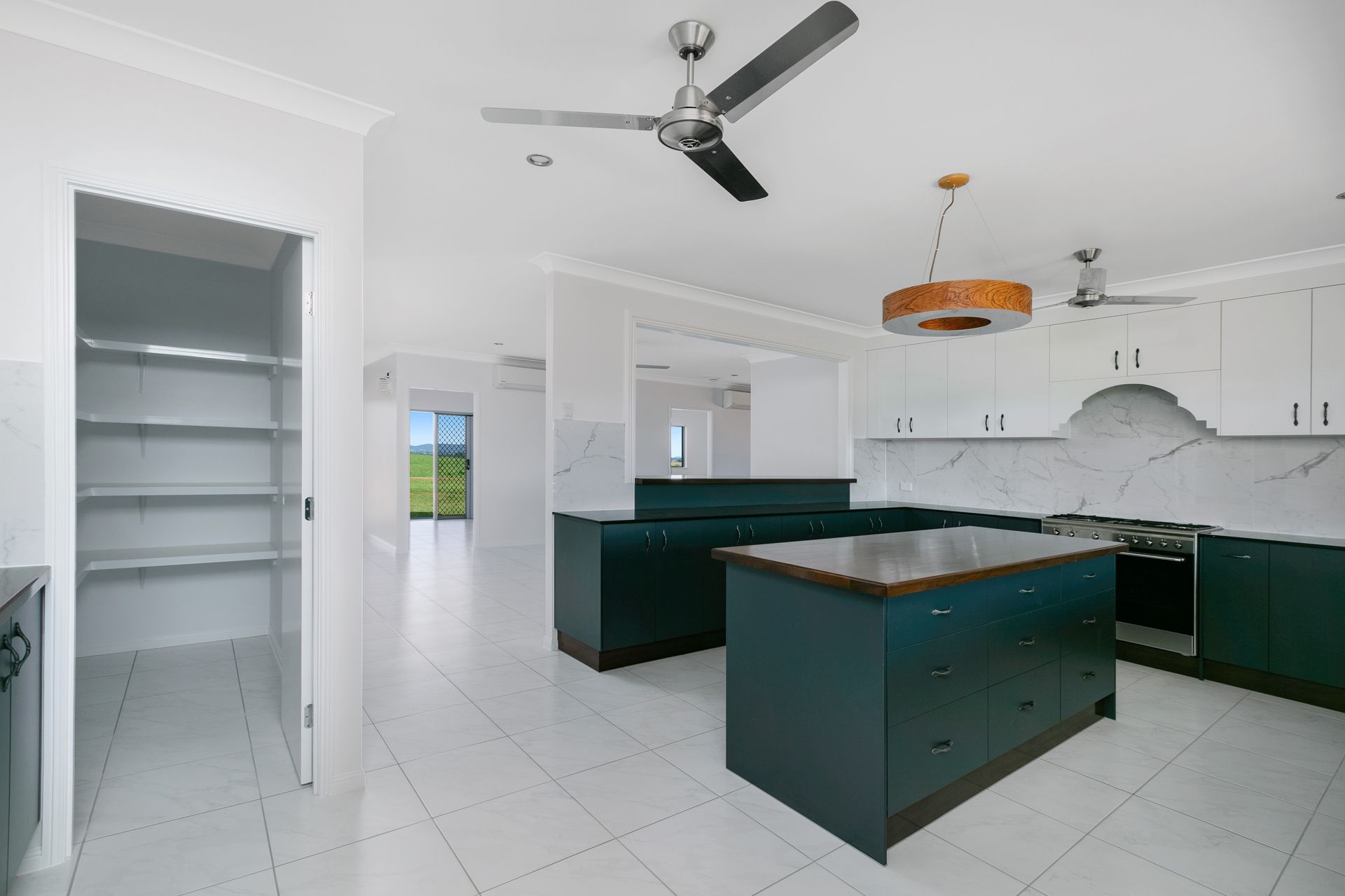 A Modern Kitchen With Dark Green Cabinets — Ashlee Jones Homes in Gordonvale, QLD