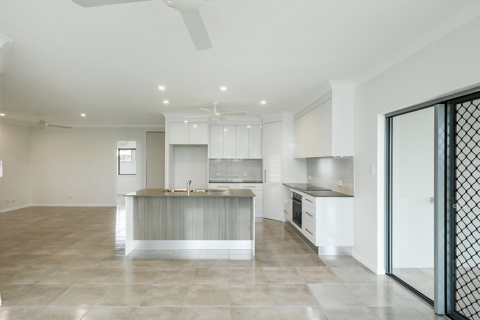 Modern Open-plan Kitchen and Living Area With White Walls — Ashlee Jones Homes in Gordonvale, QLD
