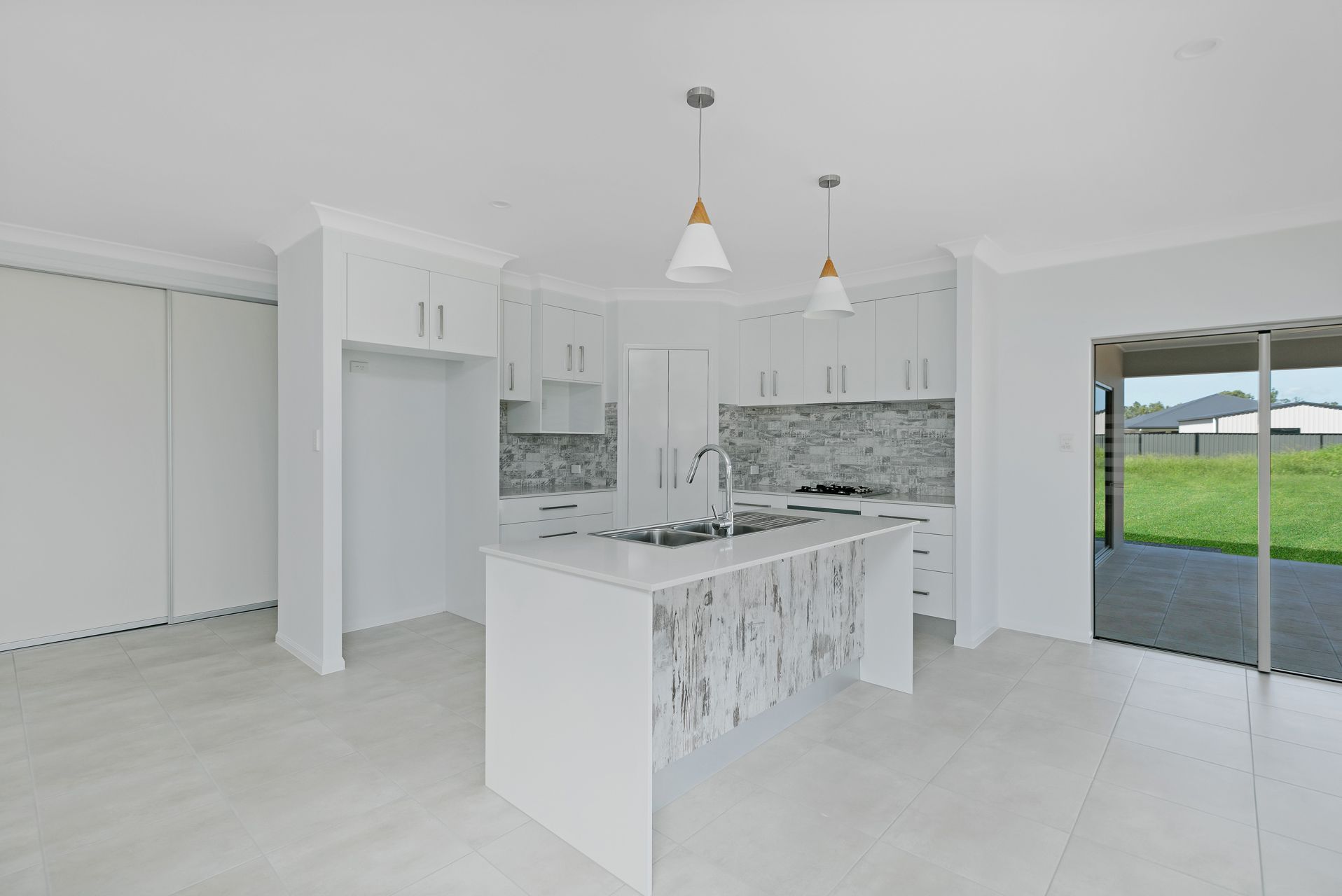 Modern Kitchen With White Cabinets, a Marble-patterned Island — Ashlee Jones Homes in Gordonvale, QLD