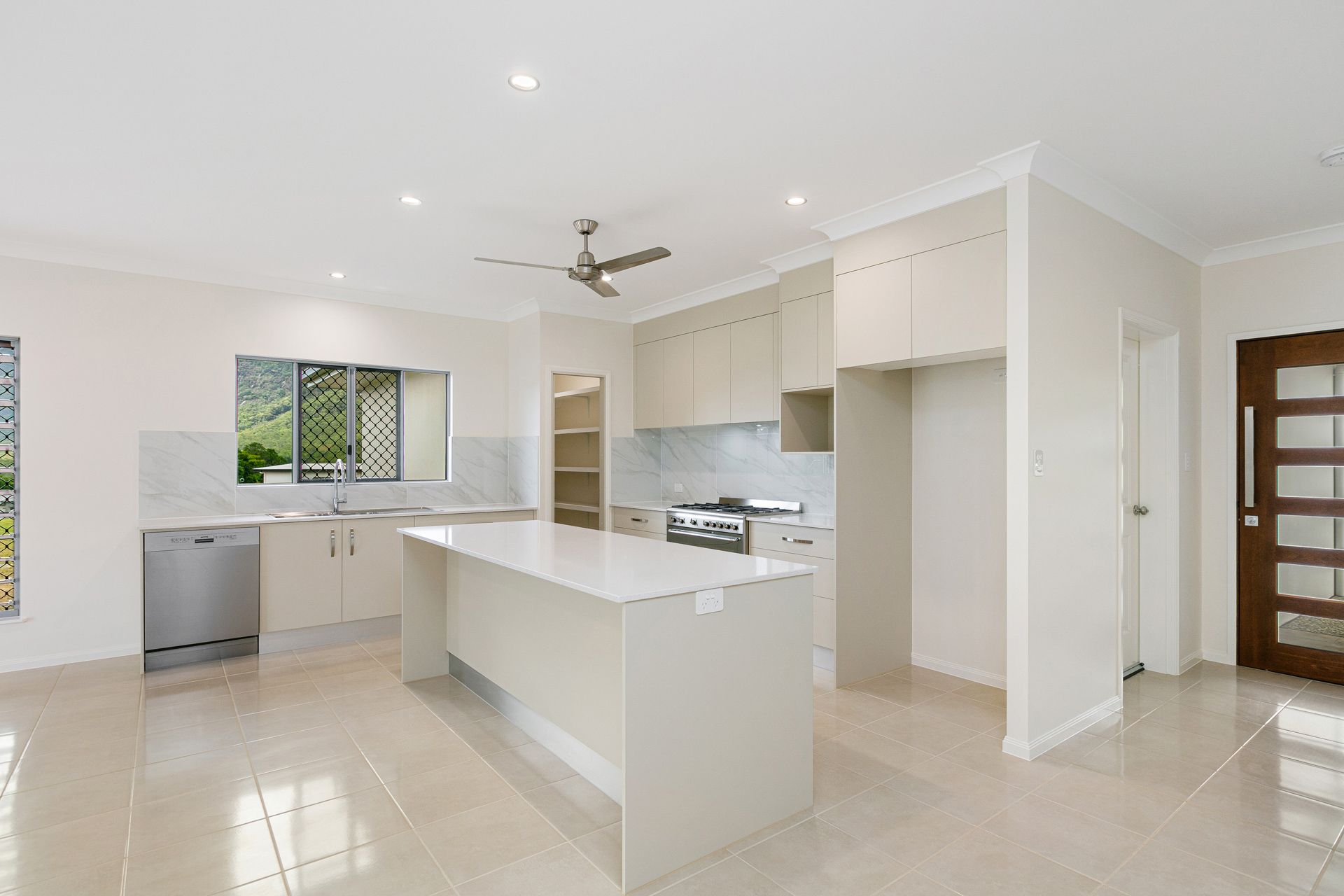 A Bright, Modern Kitchen With White Cabinetry — Ashlee Jones Homes in Gordonvale, QLD