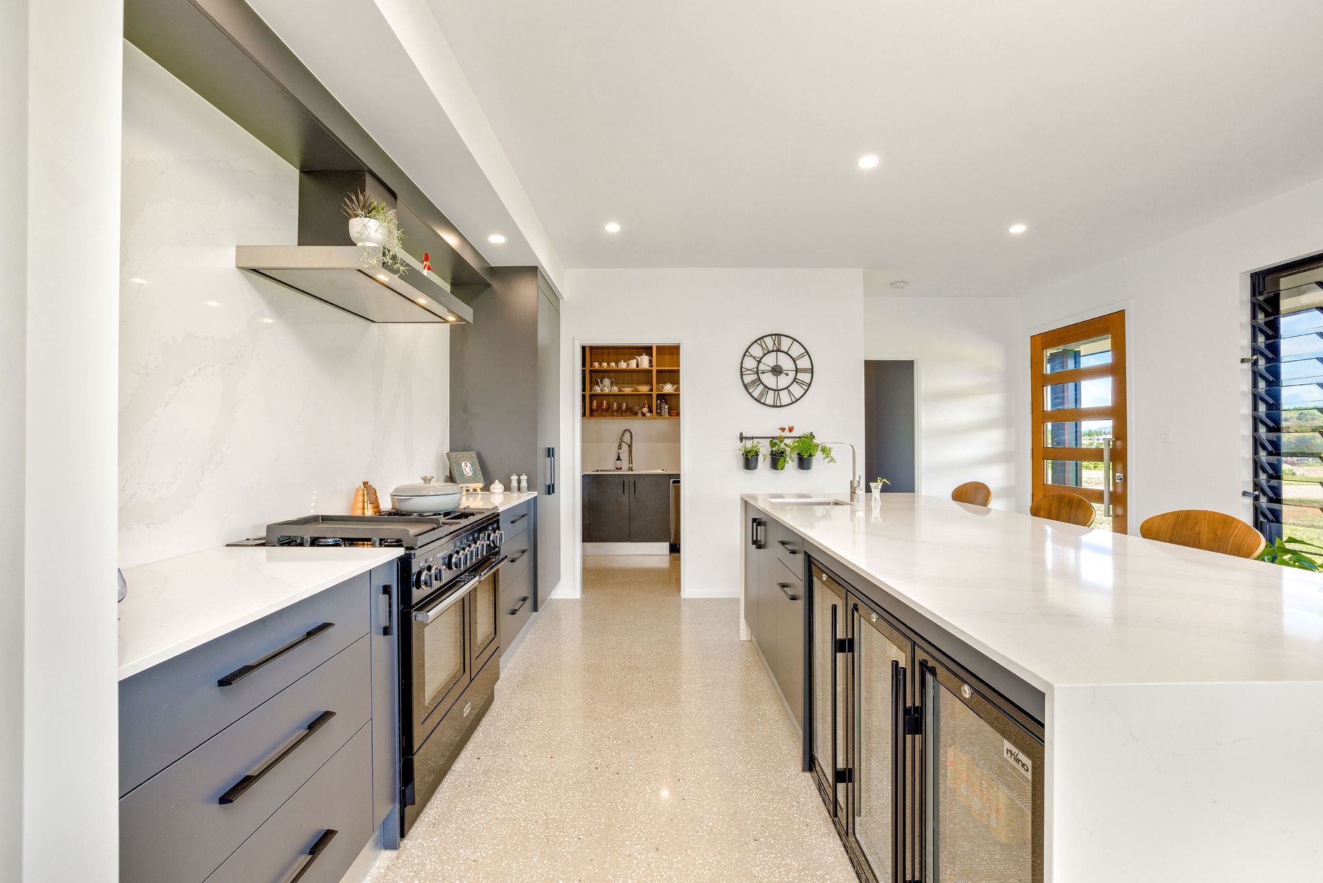 Modern Kitchen With a Long White Island, Grey Cabinetry — Ashlee Jones Homes in Gordonvale, QLD