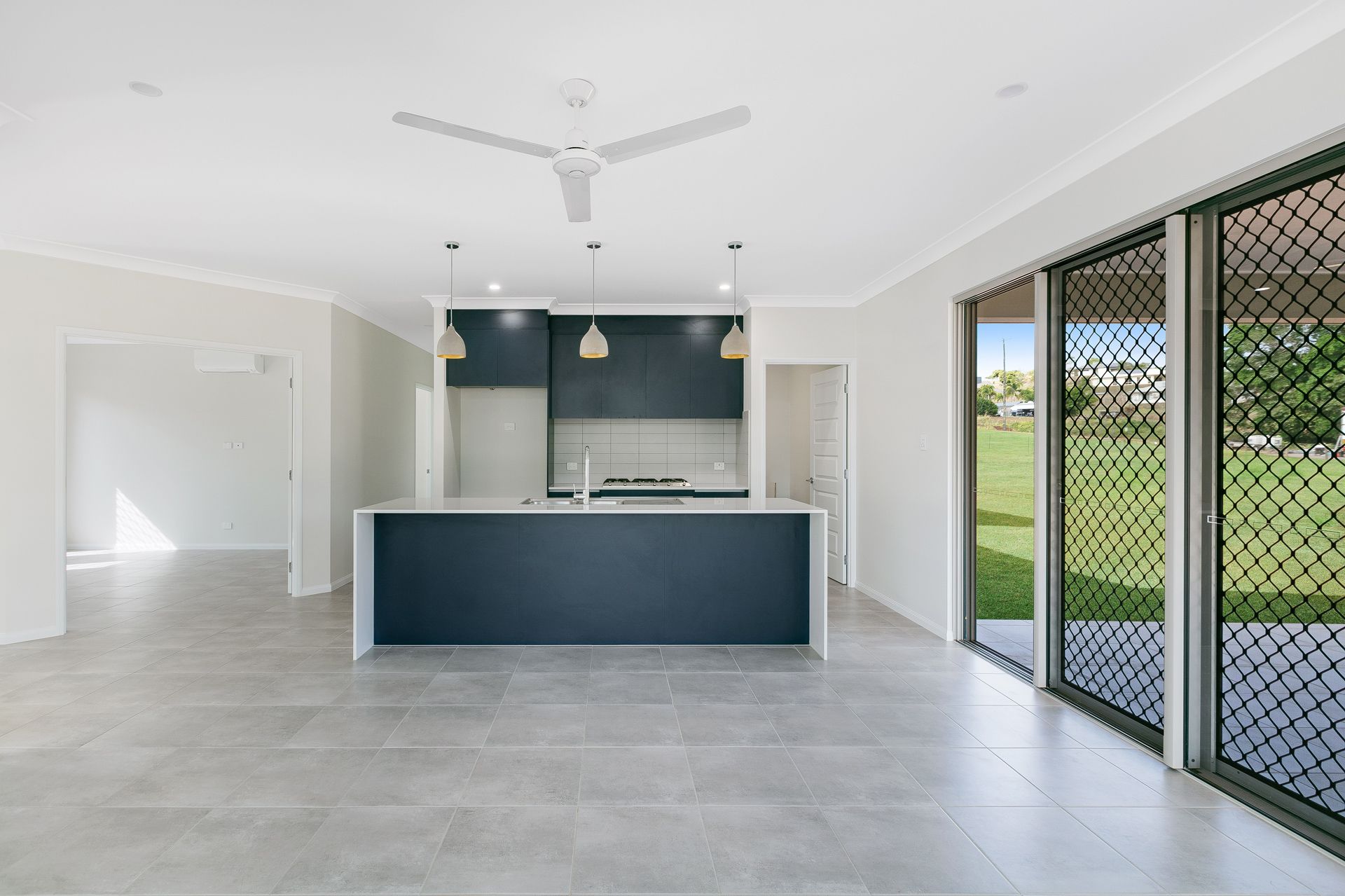 Modern Open-plan Kitchen With a Dark Blue Island and Cabinetry — Ashlee Jones Homes in Gordonvale, QLD