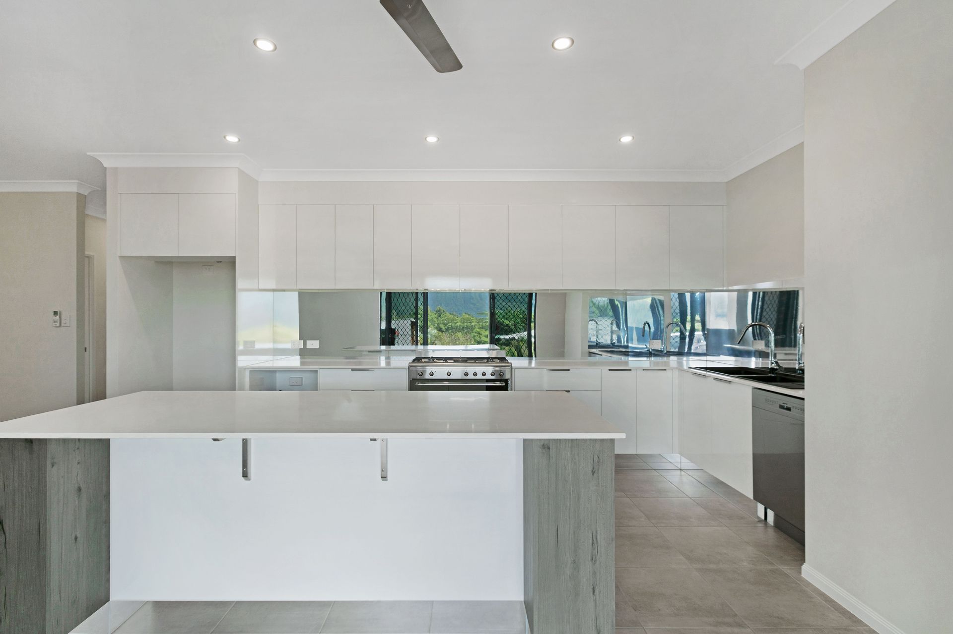 A Modern White Kitchen With a Large Island — Ashlee Jones Homes in Gordonvale, QLD