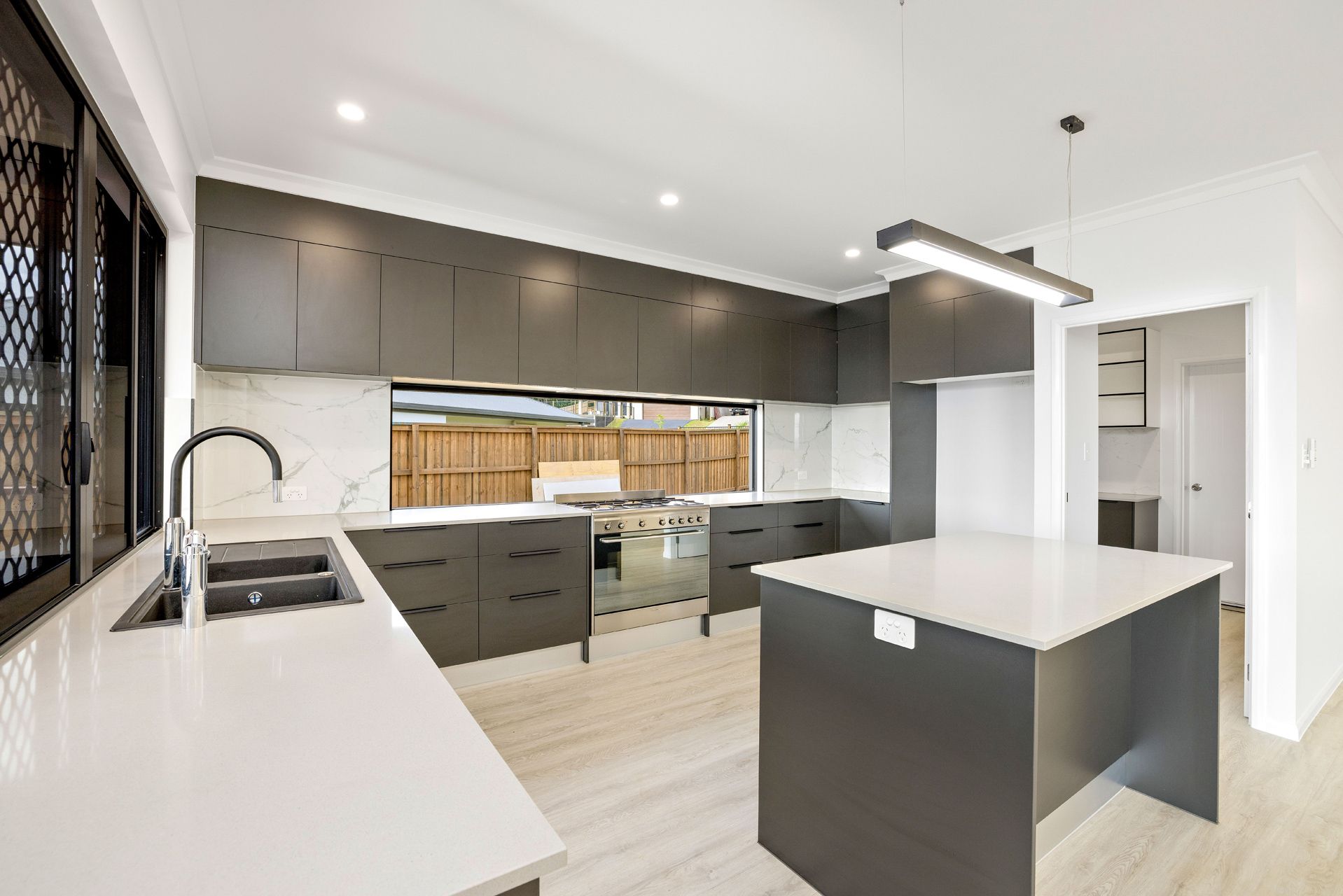Modern Kitchen Featuring Dark Grey Cabinets — Ashlee Jones Homes in Gordonvale, QLD