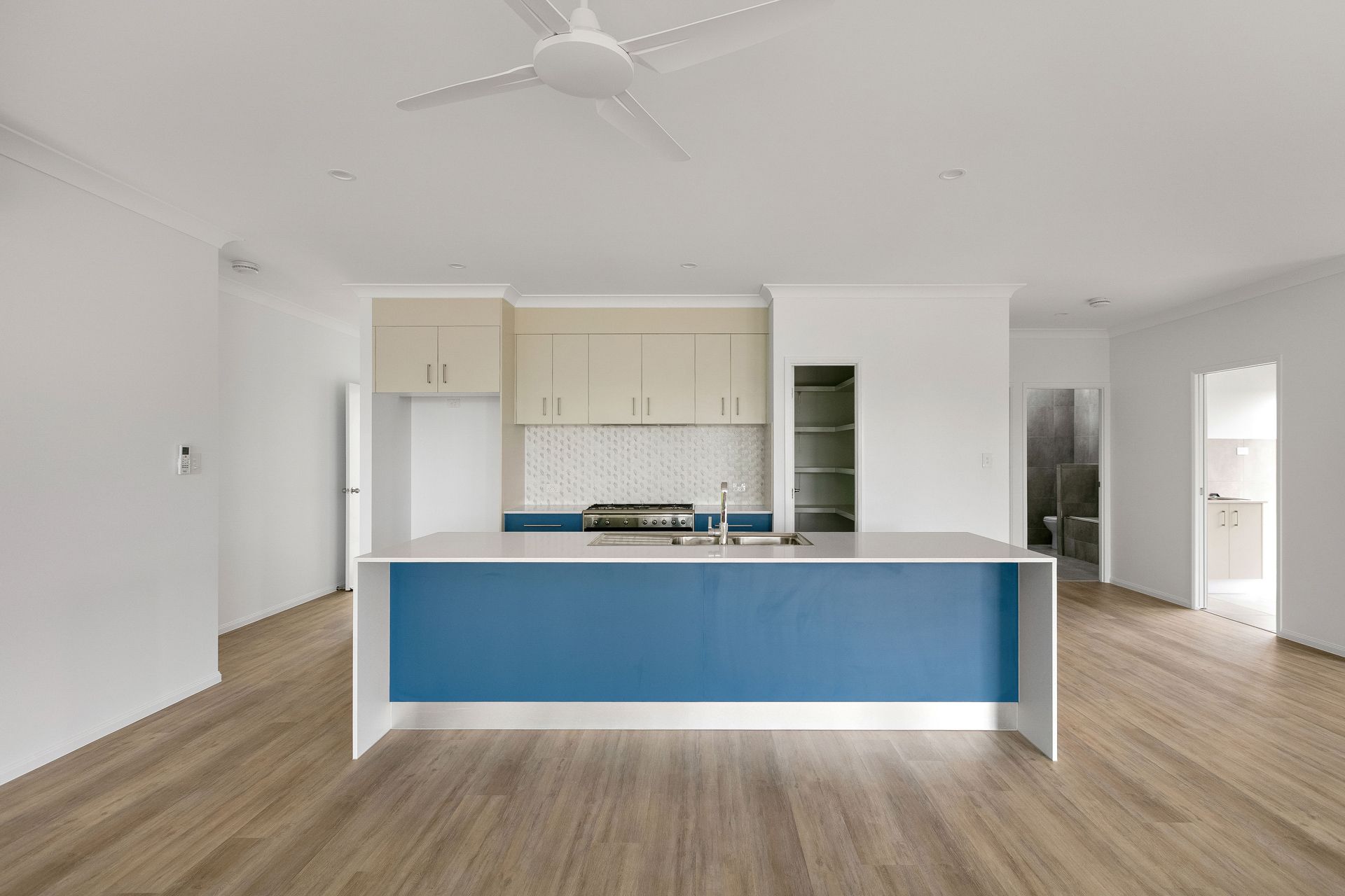 Modern Kitchen Interior Featuring a Blue Island, Light Wood Cabinetry — Ashlee Jones Homes in Gordonvale, QLD