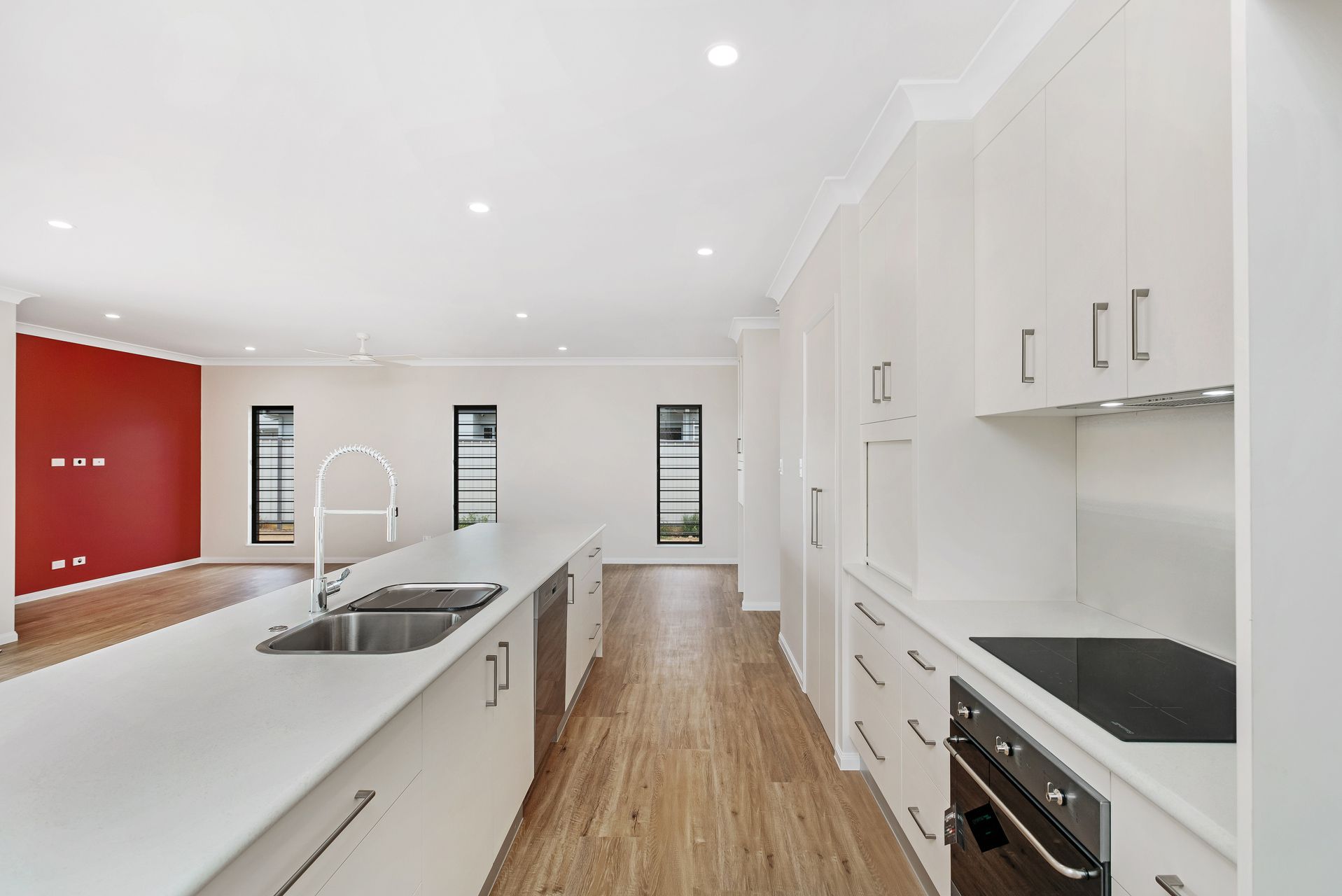 A Modern Kitchen With White Cabinets, a Large Island — Ashlee Jones Homes in Gordonvale, QLD
