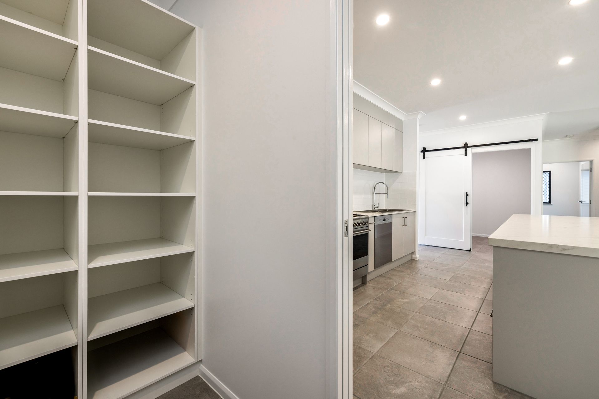 A Pantry With Empty White Shelves — Ashlee Jones Homes in Gordonvale, QLD