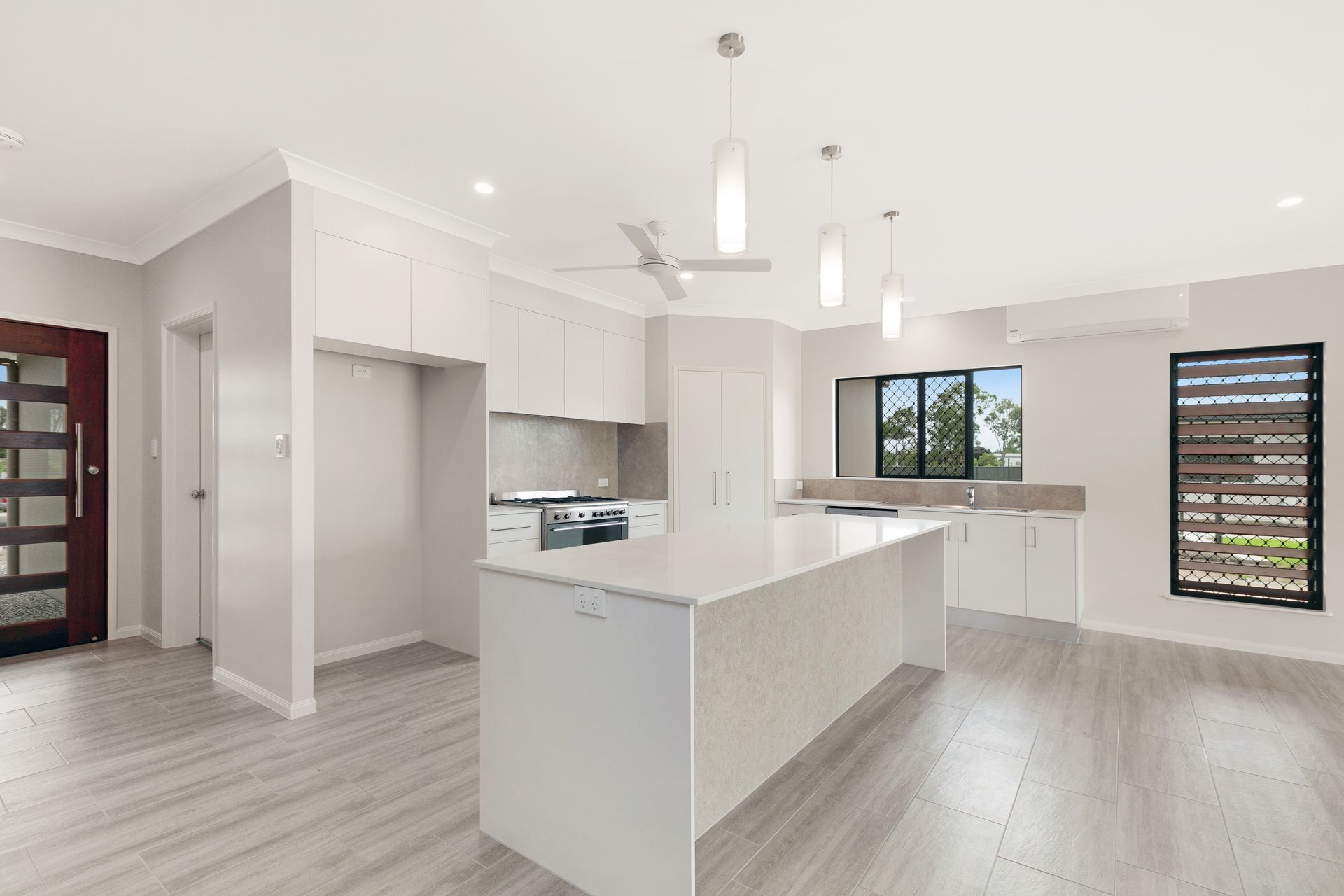 A Modern, Open-plan Kitchen With a White Island — Ashlee Jones Homes in Gordonvale, QLD
