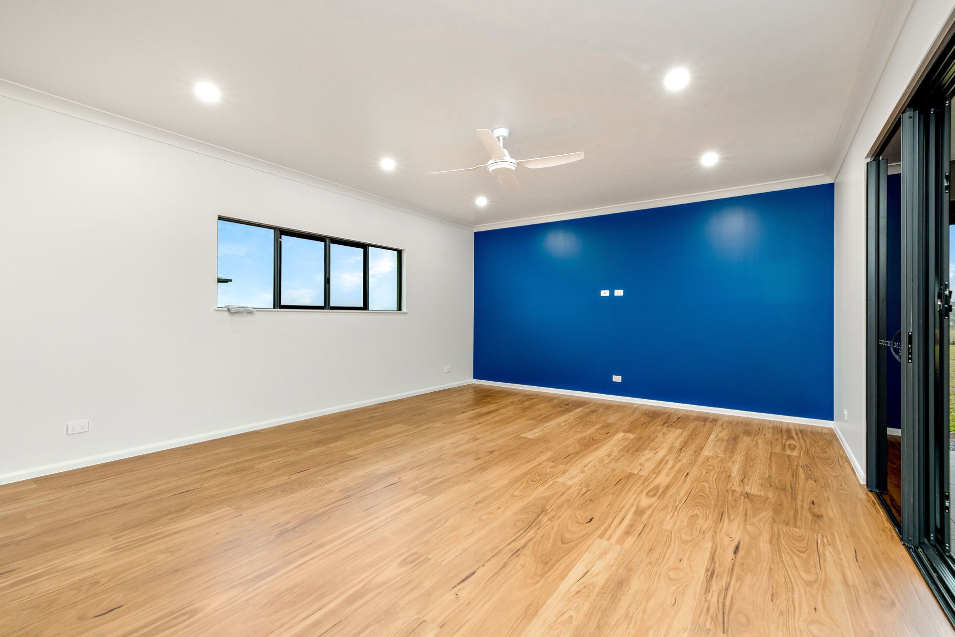 An Empty Living Room With Light Wood Flooring — Ashlee Jones Homes in Gordonvale, QLD