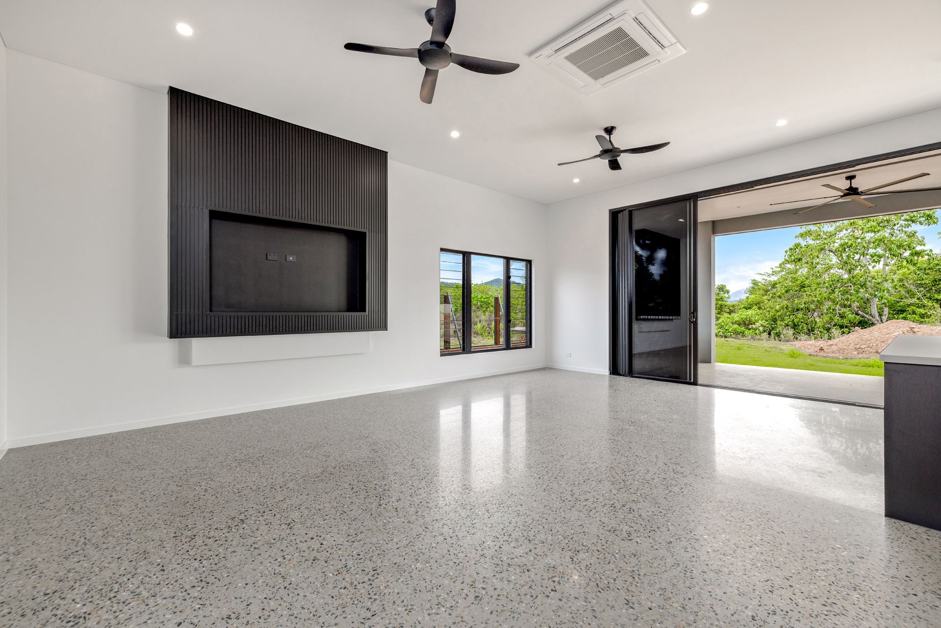 Modern Living Room With Black Paneled Wall Featuring a Recessed TV — Ashlee Jones Homes in Gordonvale, QLD