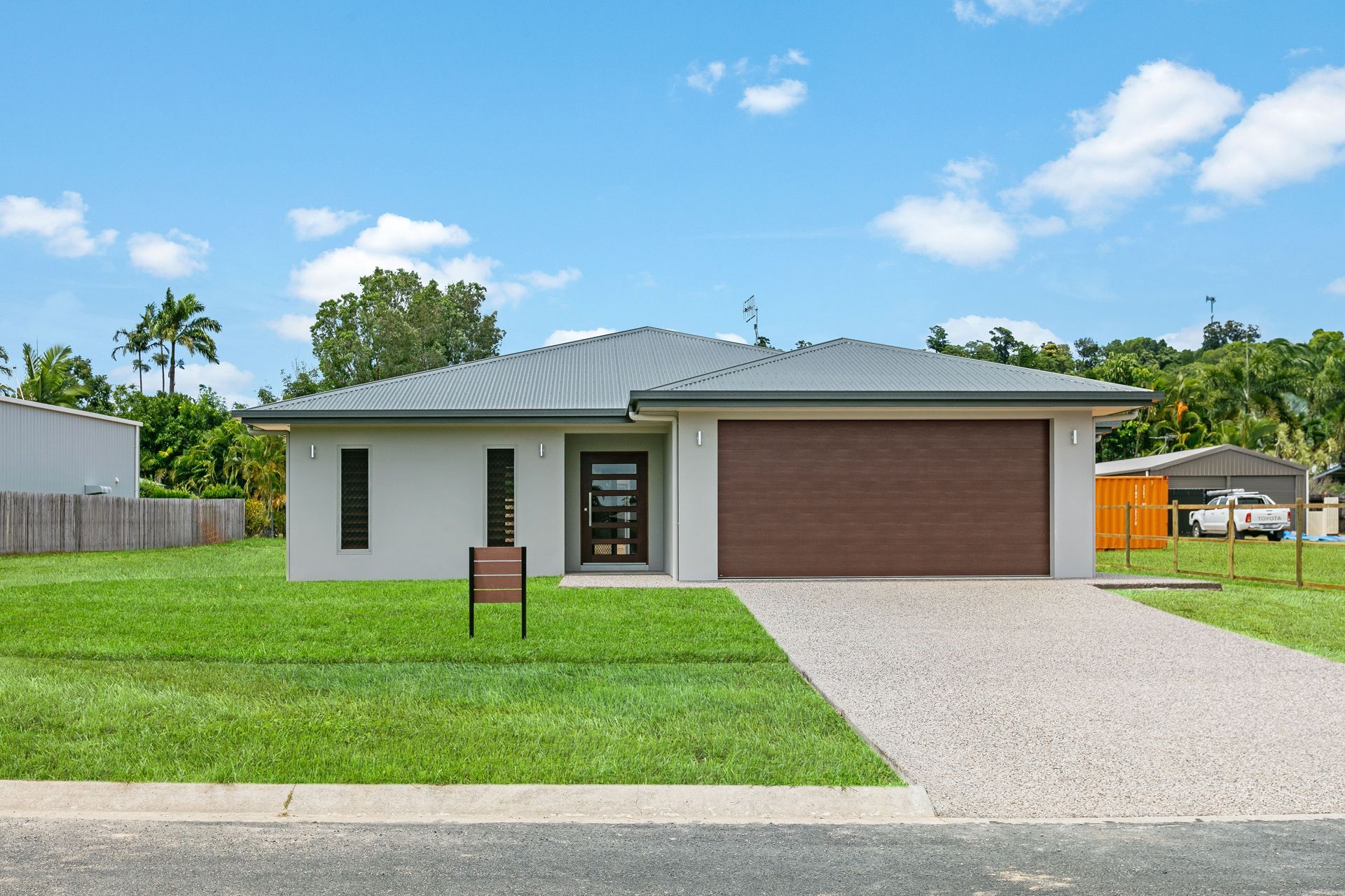 Modern Single-story Light-gray House With a Dark Roof and Large Brown Garage — Ashlee Jones Homes in Gordonvale, QLD