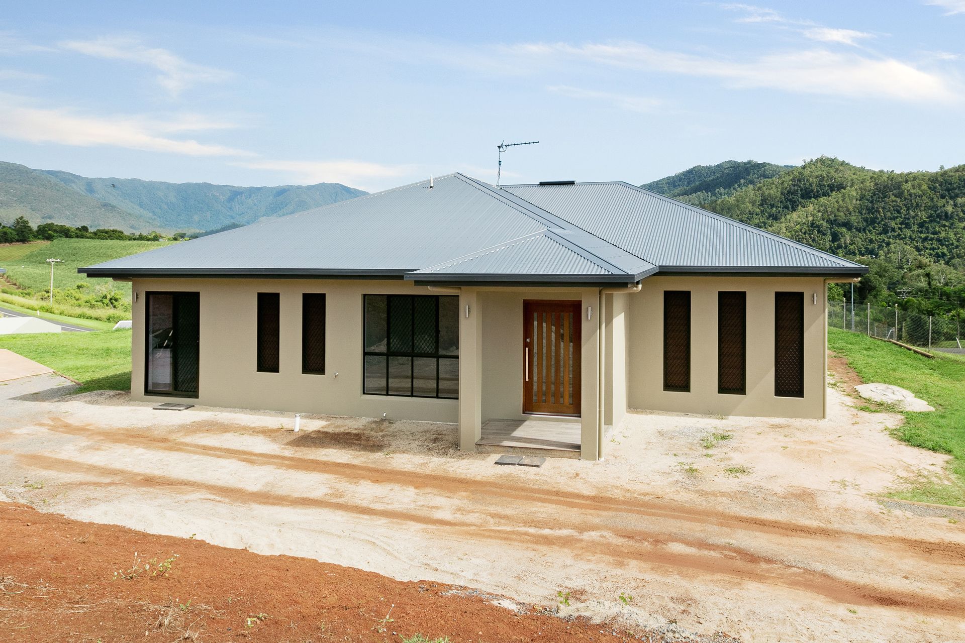 A Single-story, Beige Stucco House With a Gray Metal Roof — Ashlee Jones Homes in Gordonvale, QLD