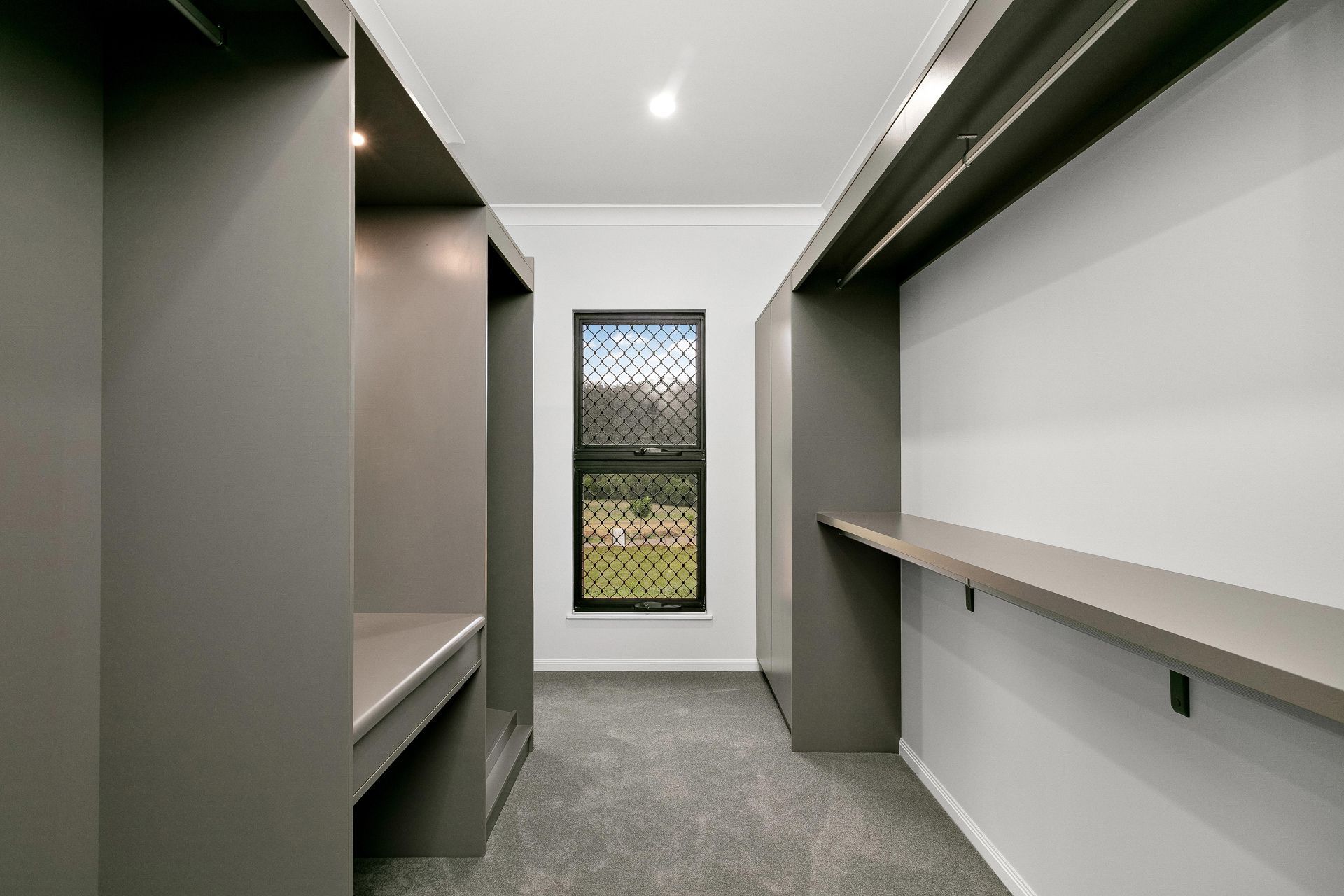 A Walk-in Closet Featuring Charcoal Gray Cabinetry — Ashlee Jones Homes in Gordonvale, QLD