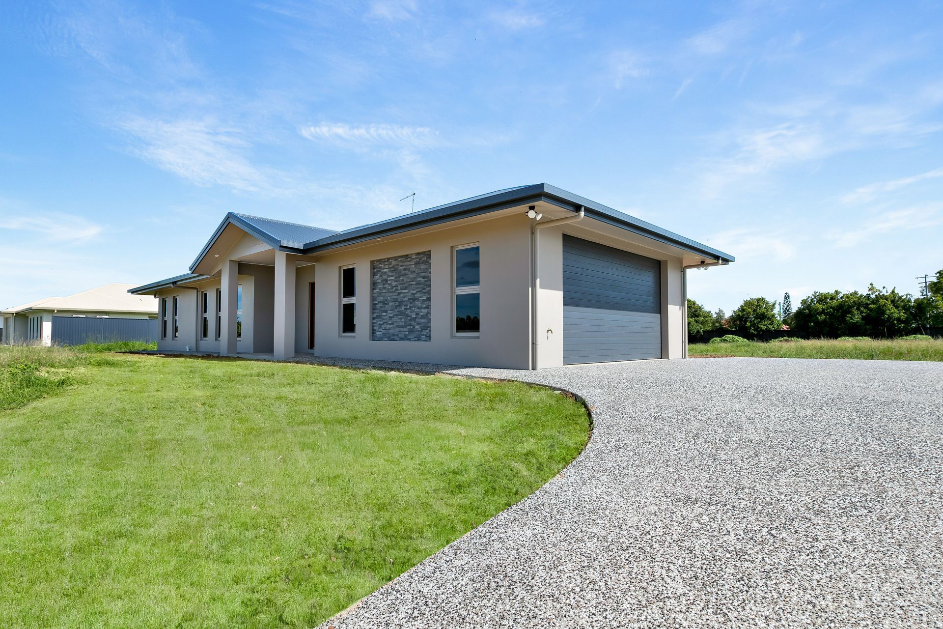 A Modern, Single-story Beige House With a Grey Roof and Garage — Ashlee Jones Homes in Gordonvale, QLD
