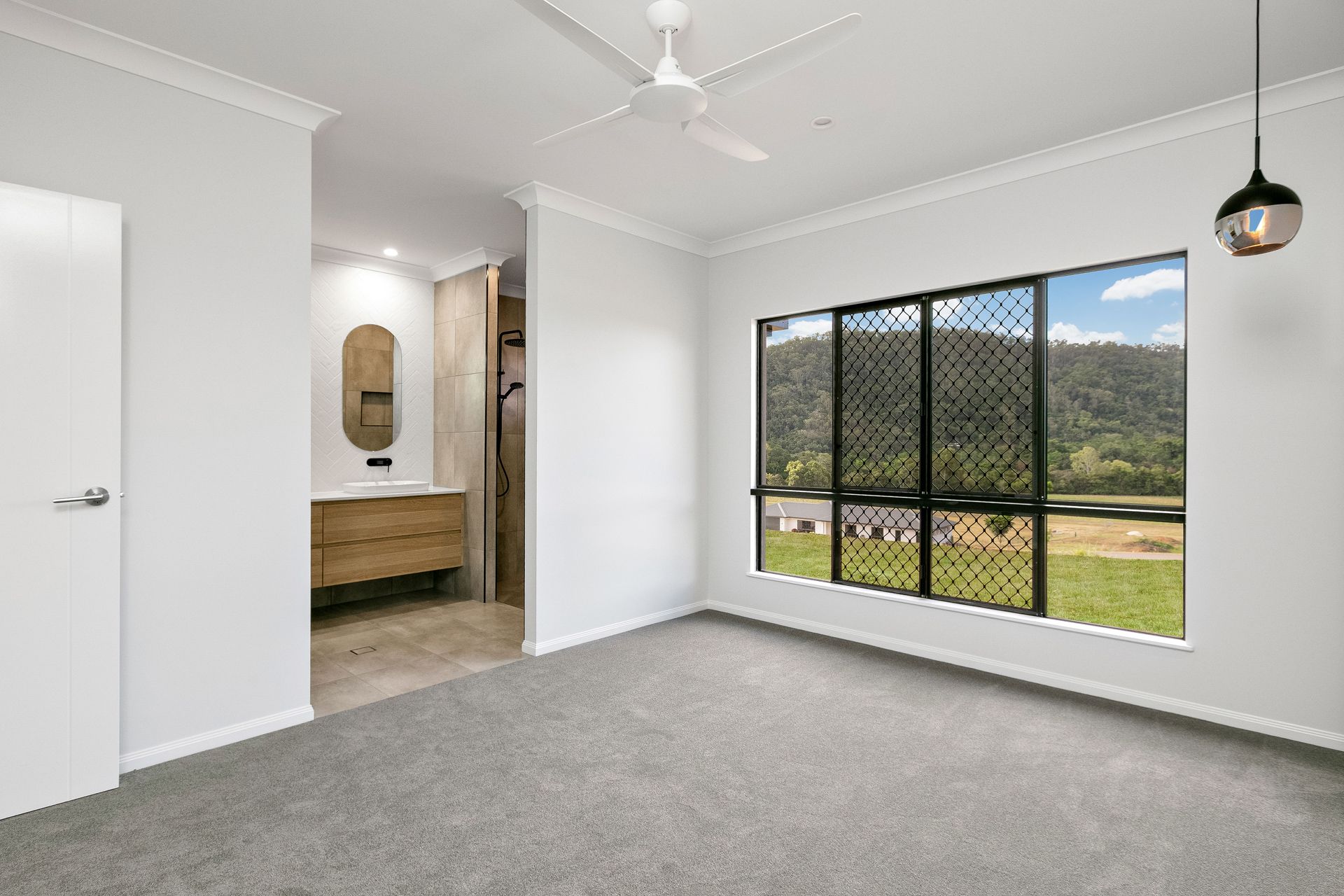 A Bright, Minimalist Bedroom With Gray Carpet — Ashlee Jones Homes in Gordonvale, QLD