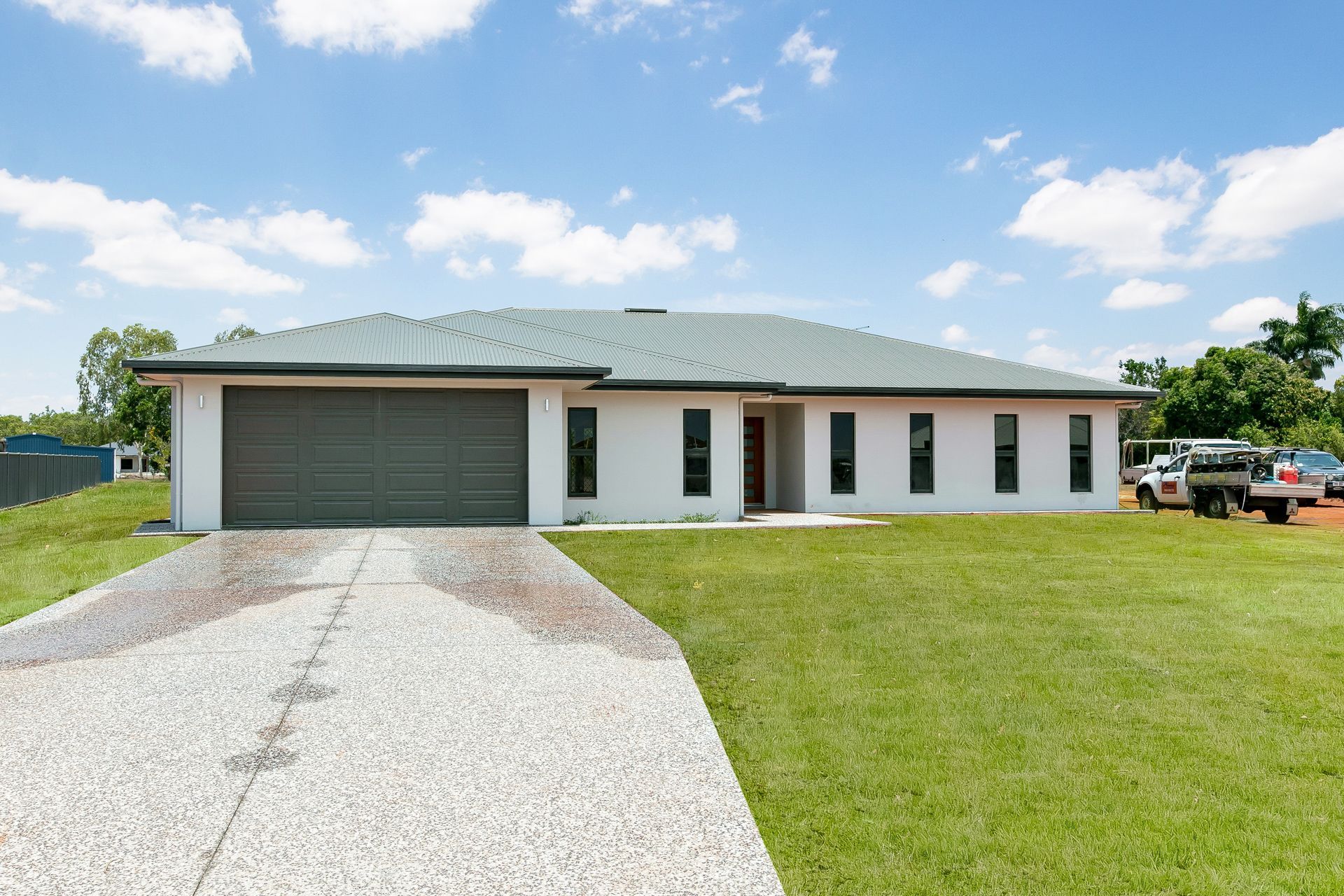 A Single-story White House With a Dark Roof and Garage — Ashlee Jones Homes in Gordonvale, QLD