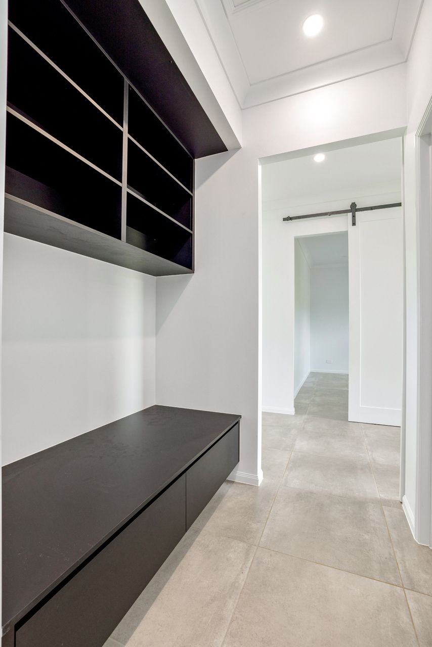 A Modern Mudroom Featuring a Dark Built-in Bench — Ashlee Jones Homes in Gordonvale, QLD