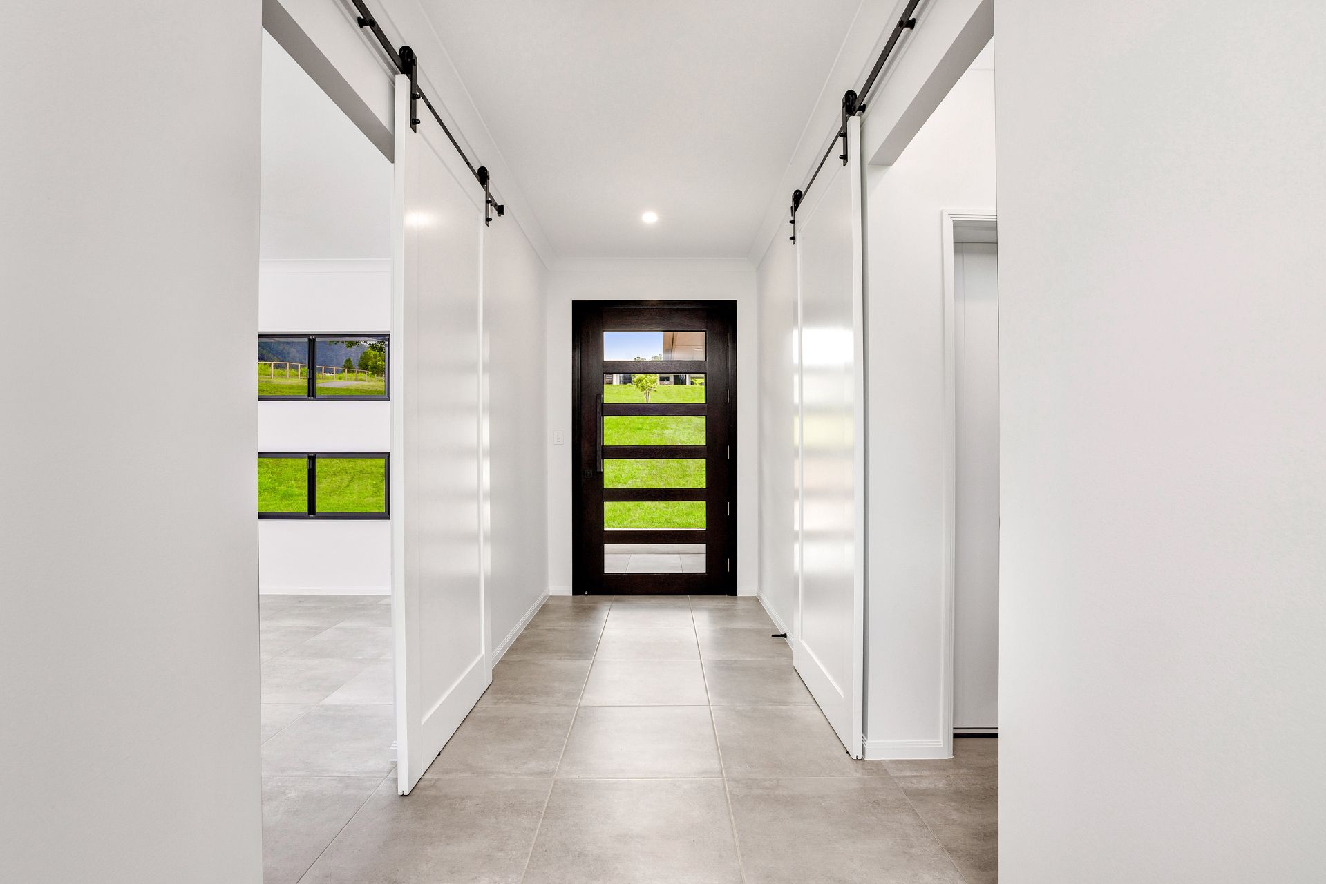 A Bright Hallway With Light Tiled Floors, White Walls — Ashlee Jones Homes in Gordonvale, QLD