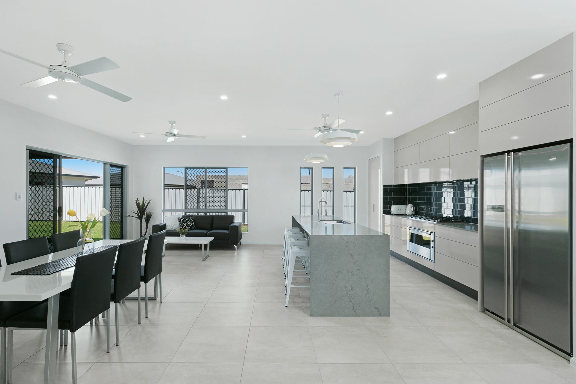 A Bright, Modern Open-plan Kitchen and Dining Area With White Walls — Ashlee Jones Homes in Gordonvale, QLD